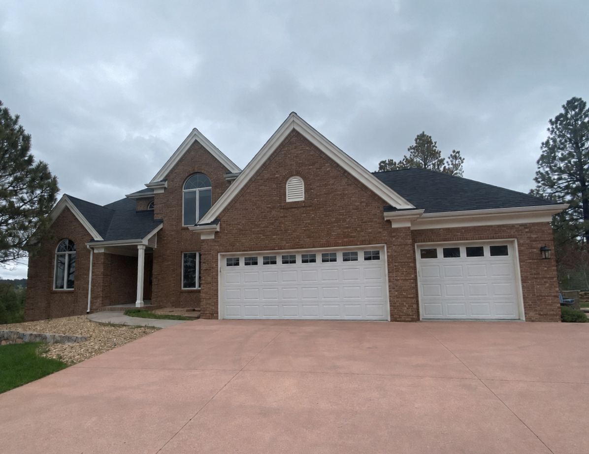 Full gutter and downspout replacement completed across the garage and multiple front-facing rooflines of a brick home.