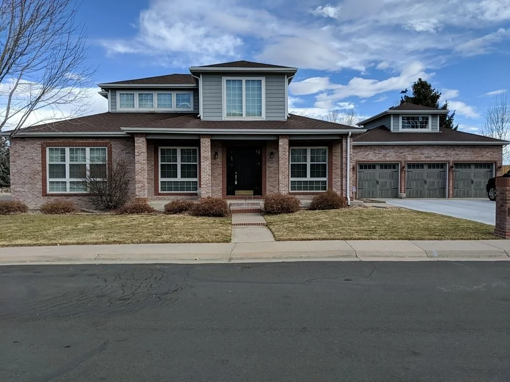 Brick and siding home with white seamless gutters in the Denver Metro area.