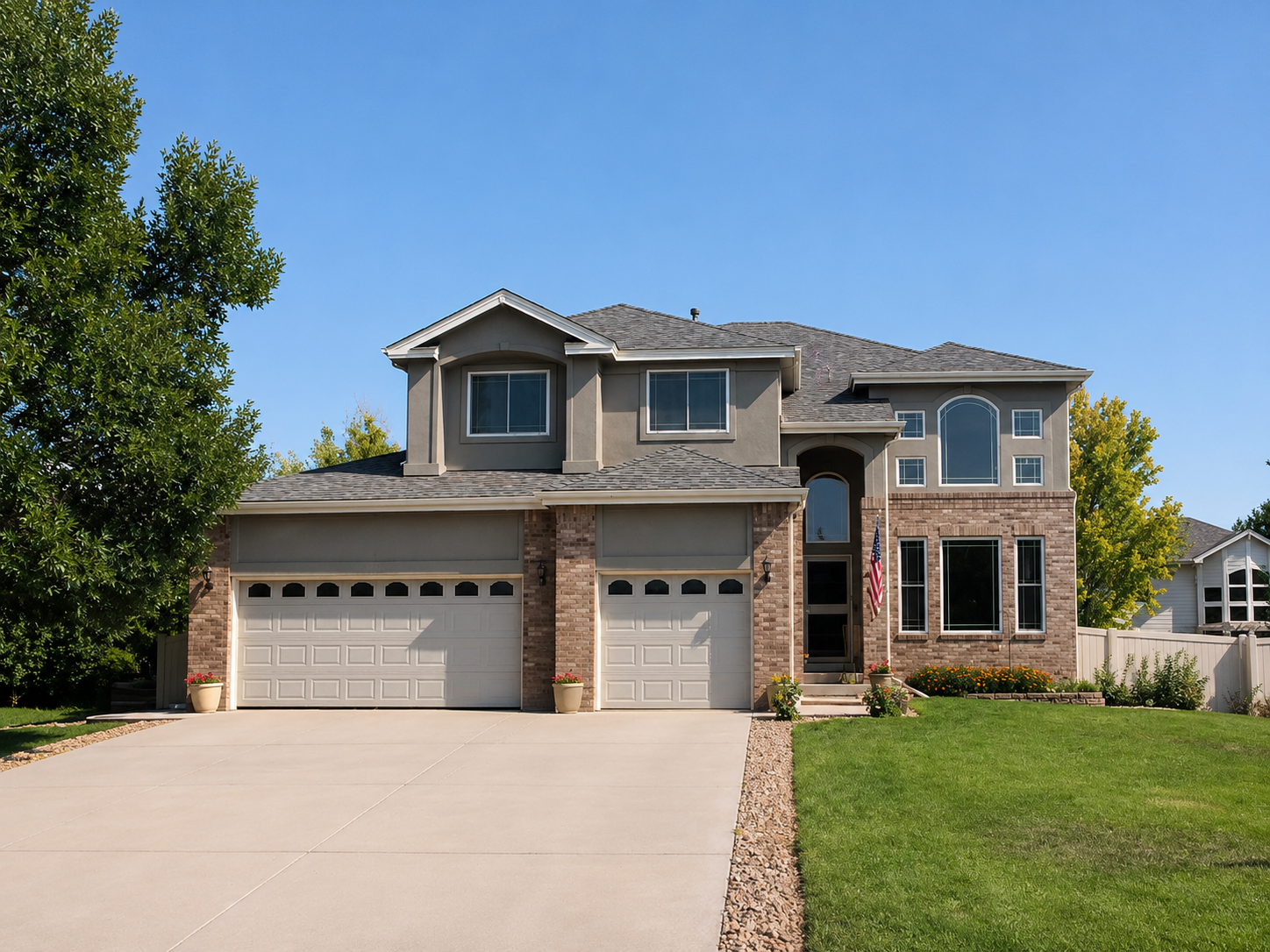 Custom seamless gutters and downspouts installed across the garage and upper roof sections of a large home.