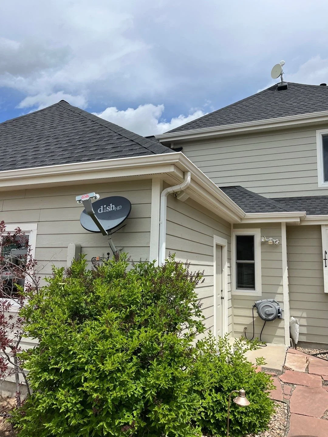 Completed white seamless gutter and downspout system fitted around the rear roofline of a Parker, CO home.