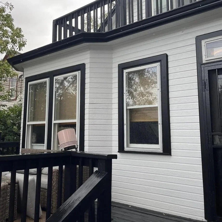 Black gutter custom-fitted around a bay window using precise hand-cut miters.