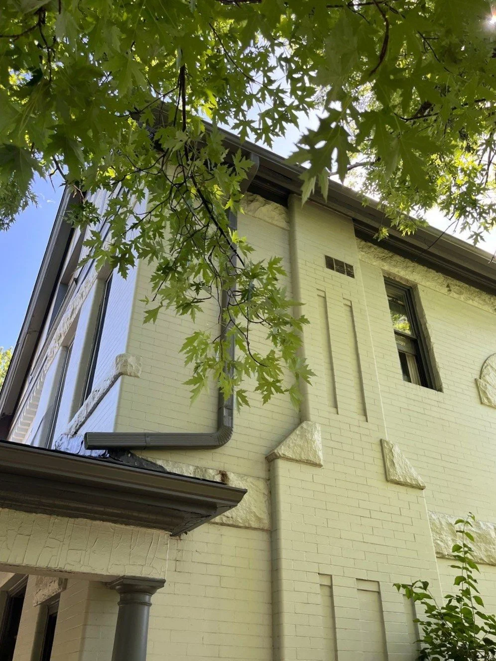 New charcoal gray 3×4-inch downspout installed on the back of a Congress Park home in Denver.