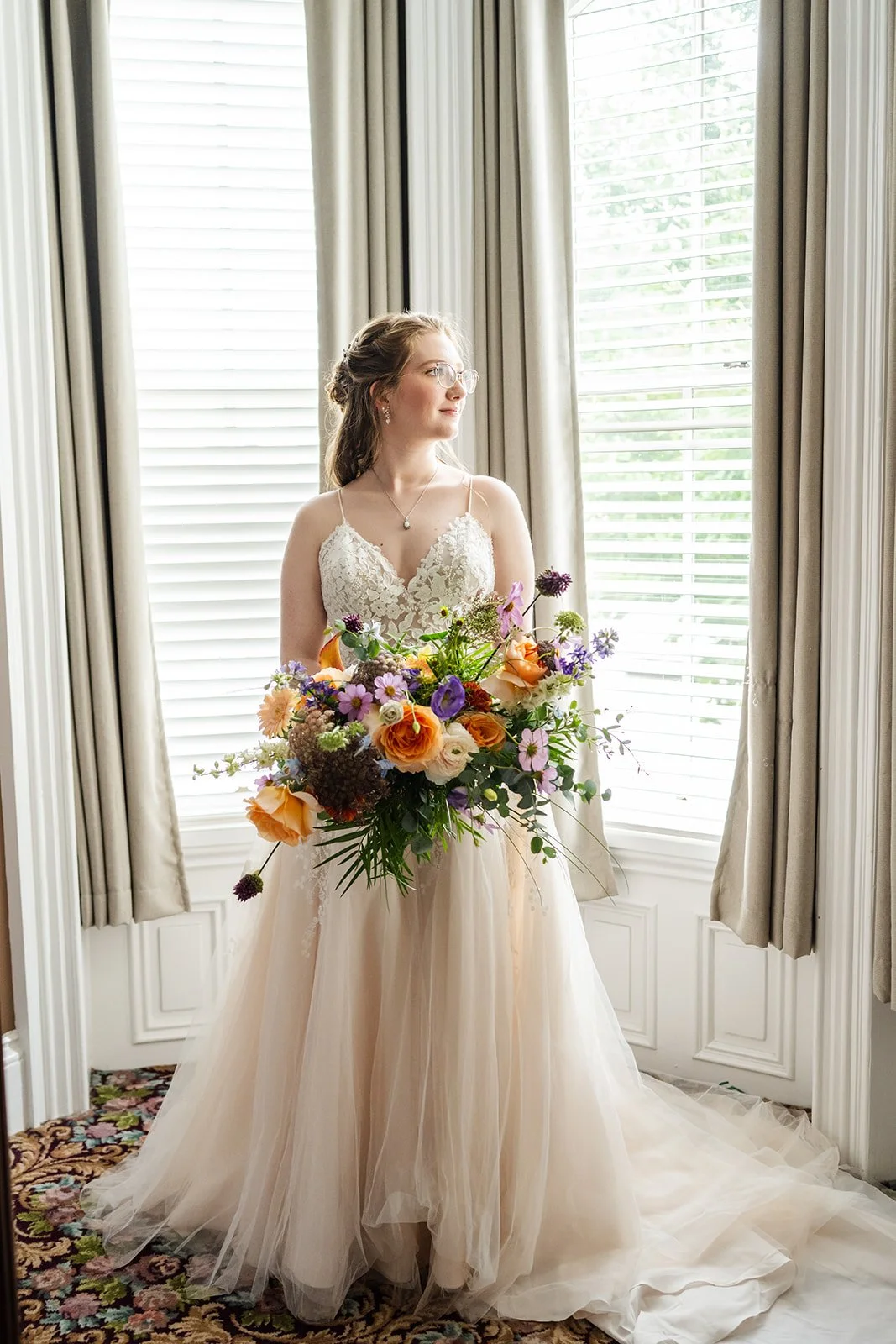 Bride holding bouquet looking out of window