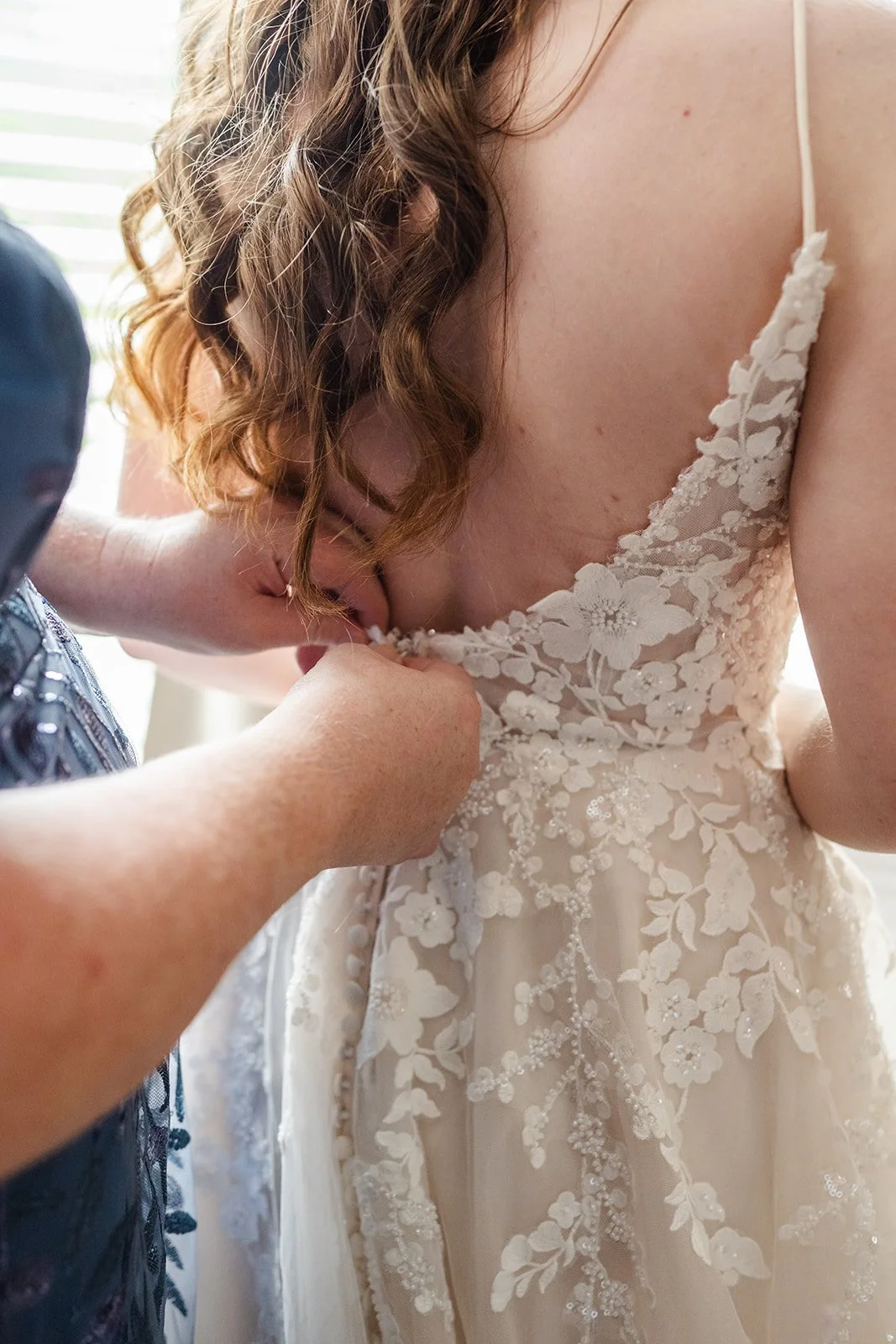 woman buttoning wedding dress