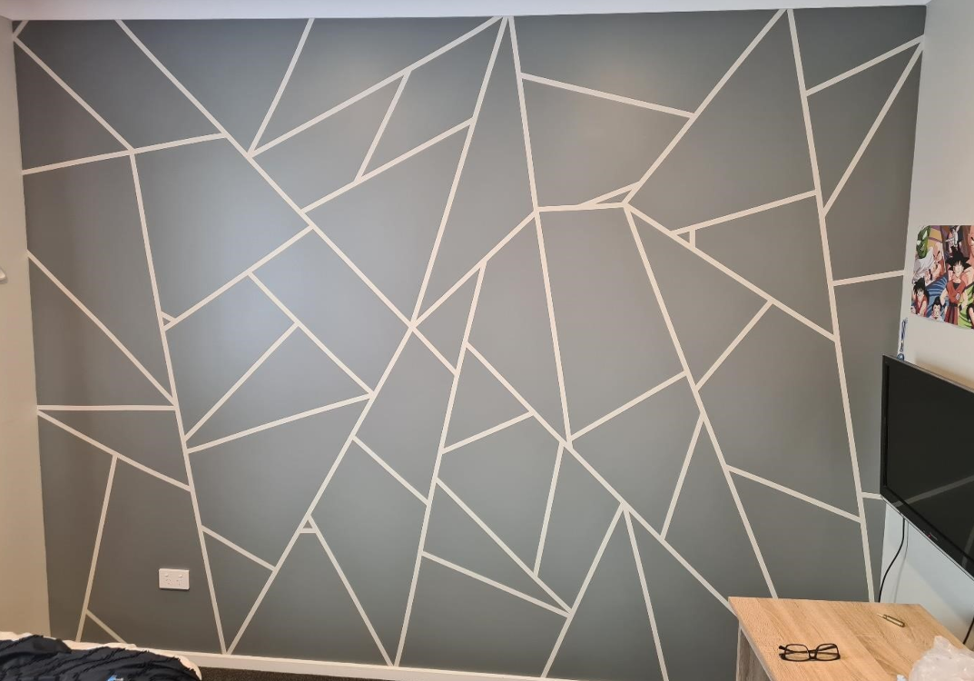 Interior wall painted with an abstract geometric pattern of white lines on a gray background.