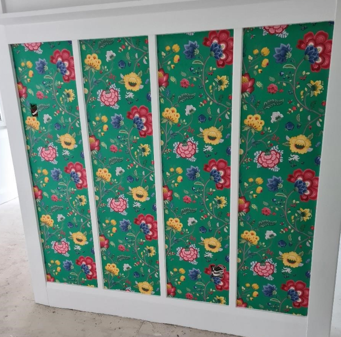 Four white lockers with floral patterns on the doors, featuring pink, yellow, blue, and purple flowers and green backgrounds.