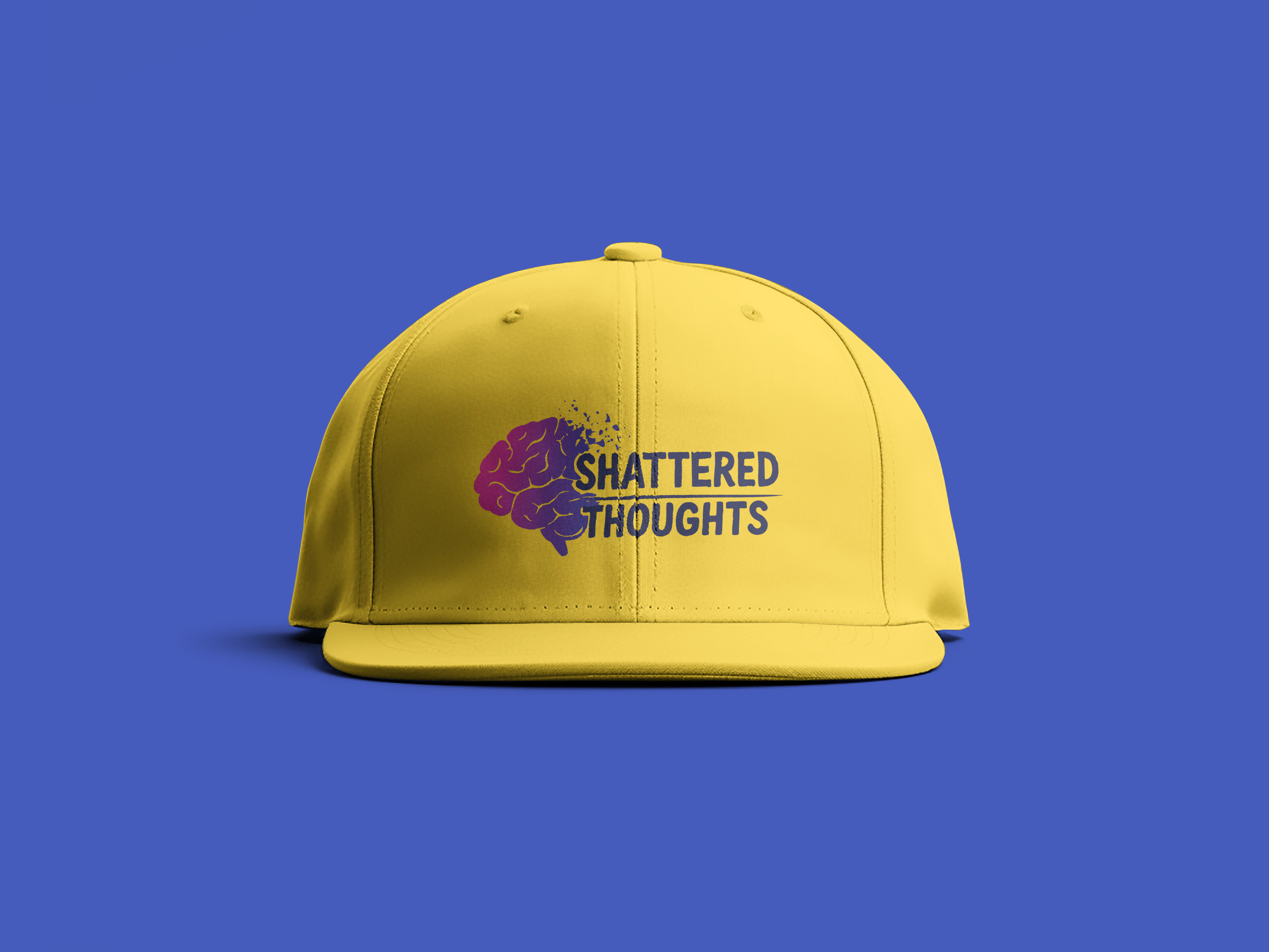Yellow cap with a graphic of a purple brain and the words "Shattered Thoughts" on a blue background.