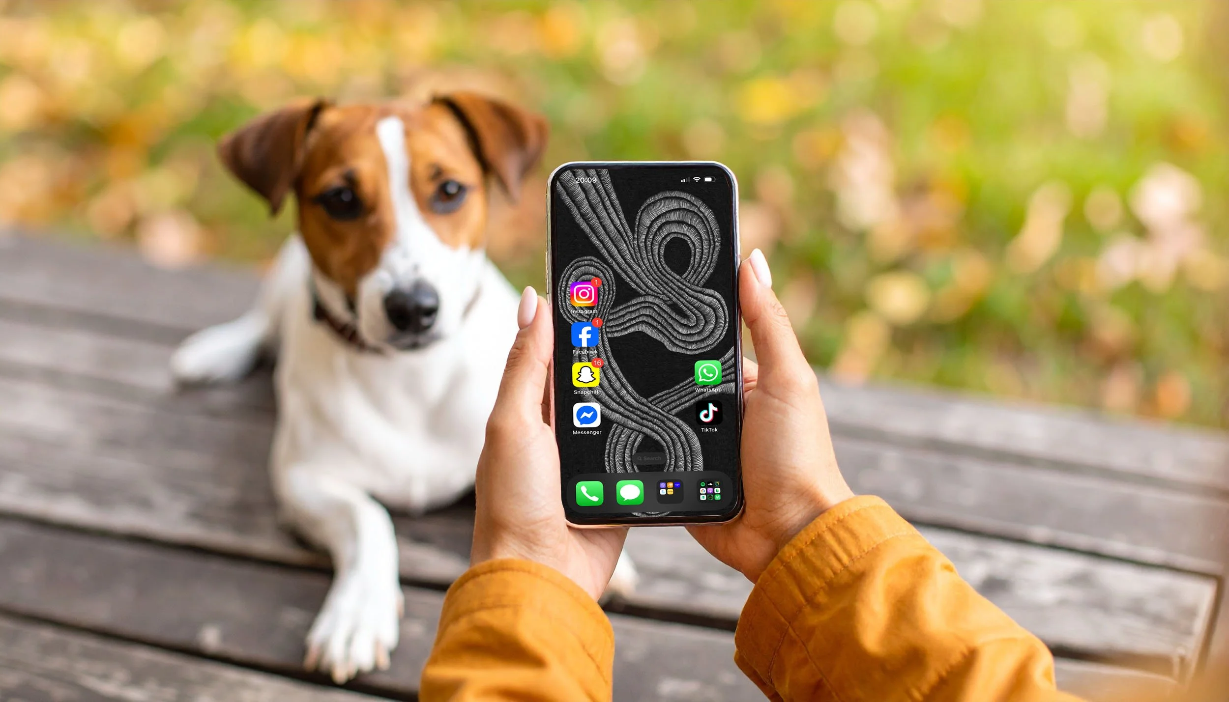 Women-holding-apple-phone-with-unconscious-flow-line-art-wallpaper-with-home-screen-and-pointing-phone-to-a-dog-sitting-on-a-park-bench.jpg