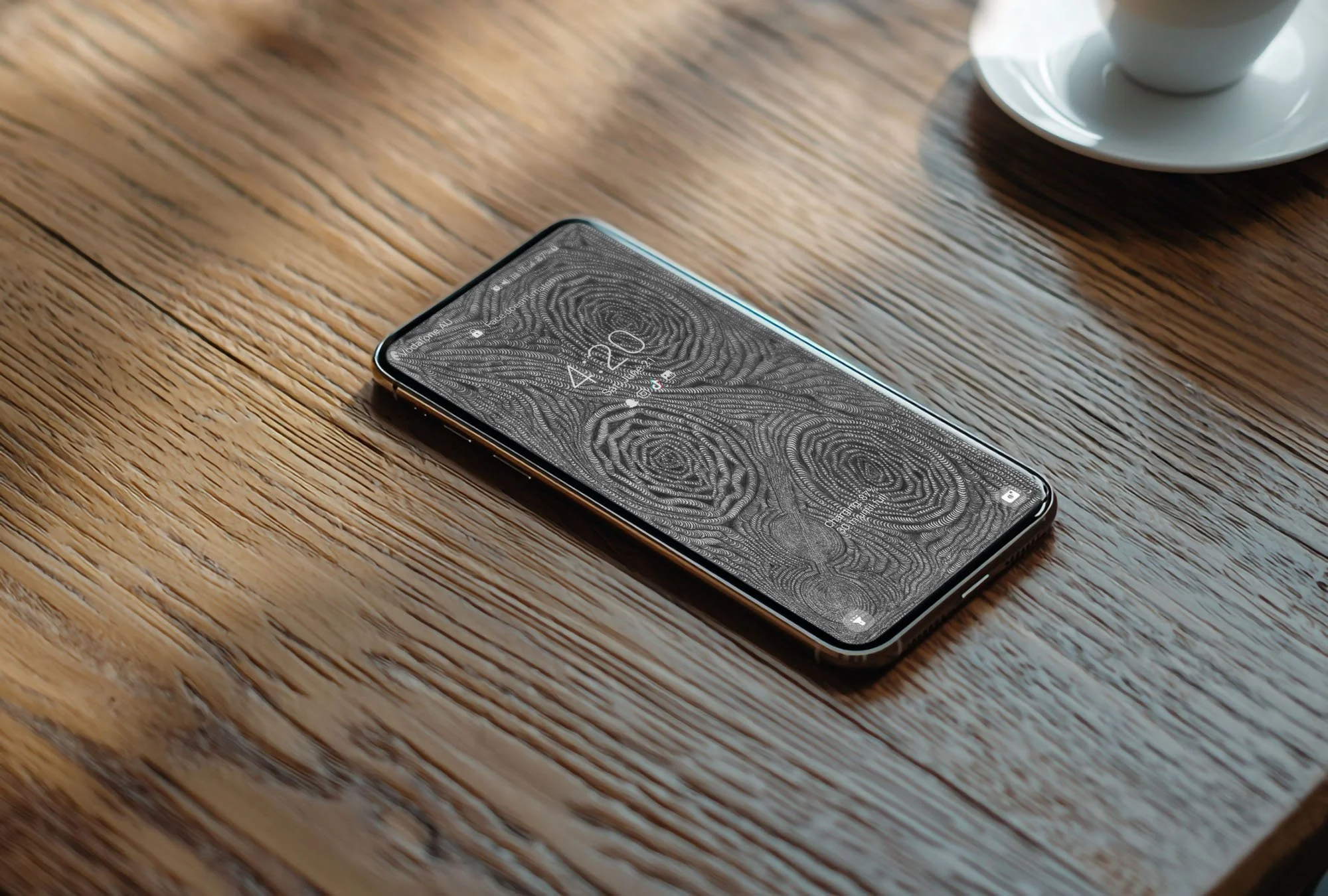 Samsung-phone-with-black-and-white-line-art-wallpaper-with-lockscreen-laying-on-grainy-wooden-table-with-sun-and-shadow-background.jpg