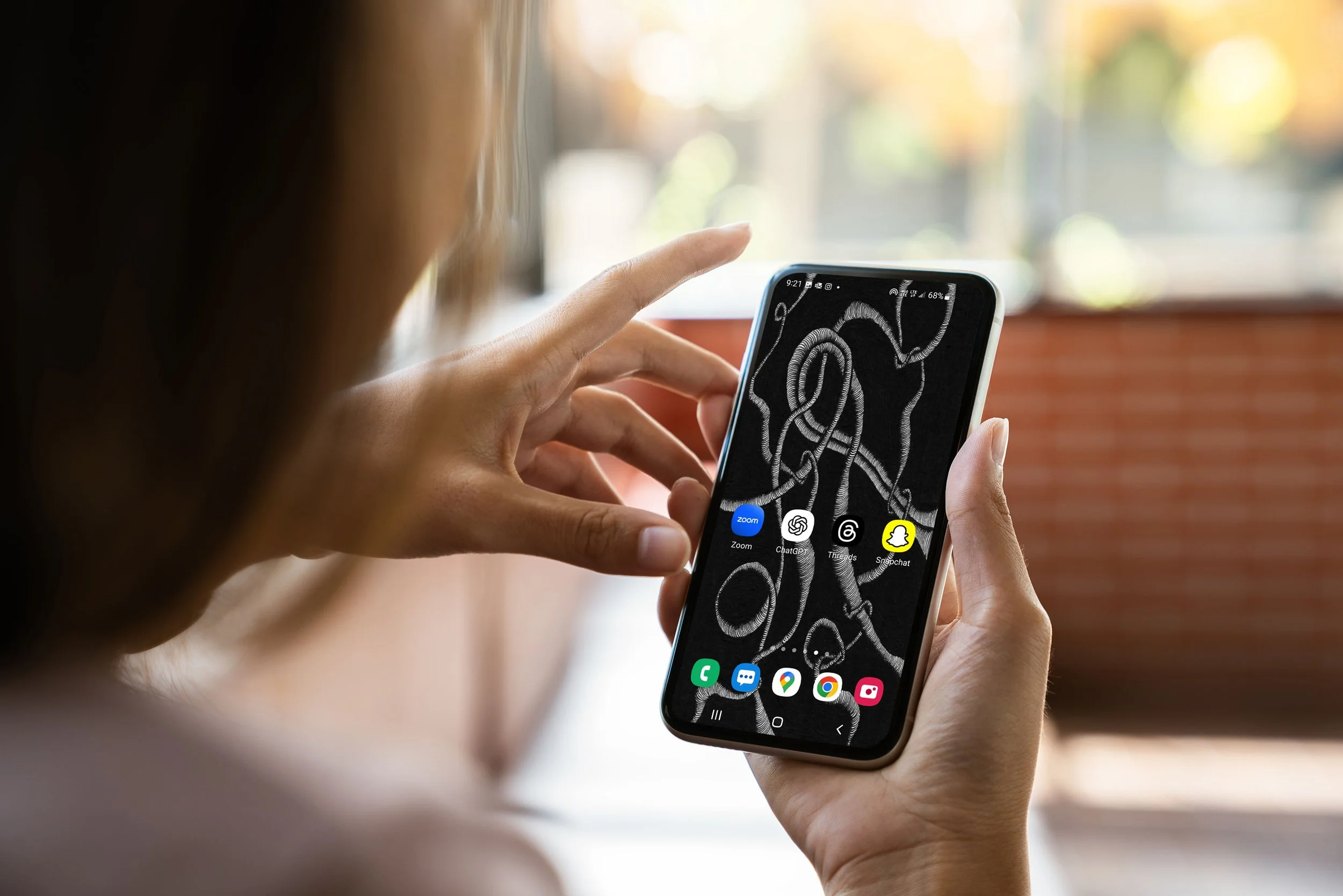 Women-with-long-hair-indoors-holding-android-phone-with-wallpaper-of-unconscious-flow-line-art-with-blurry-backgroun.jpg