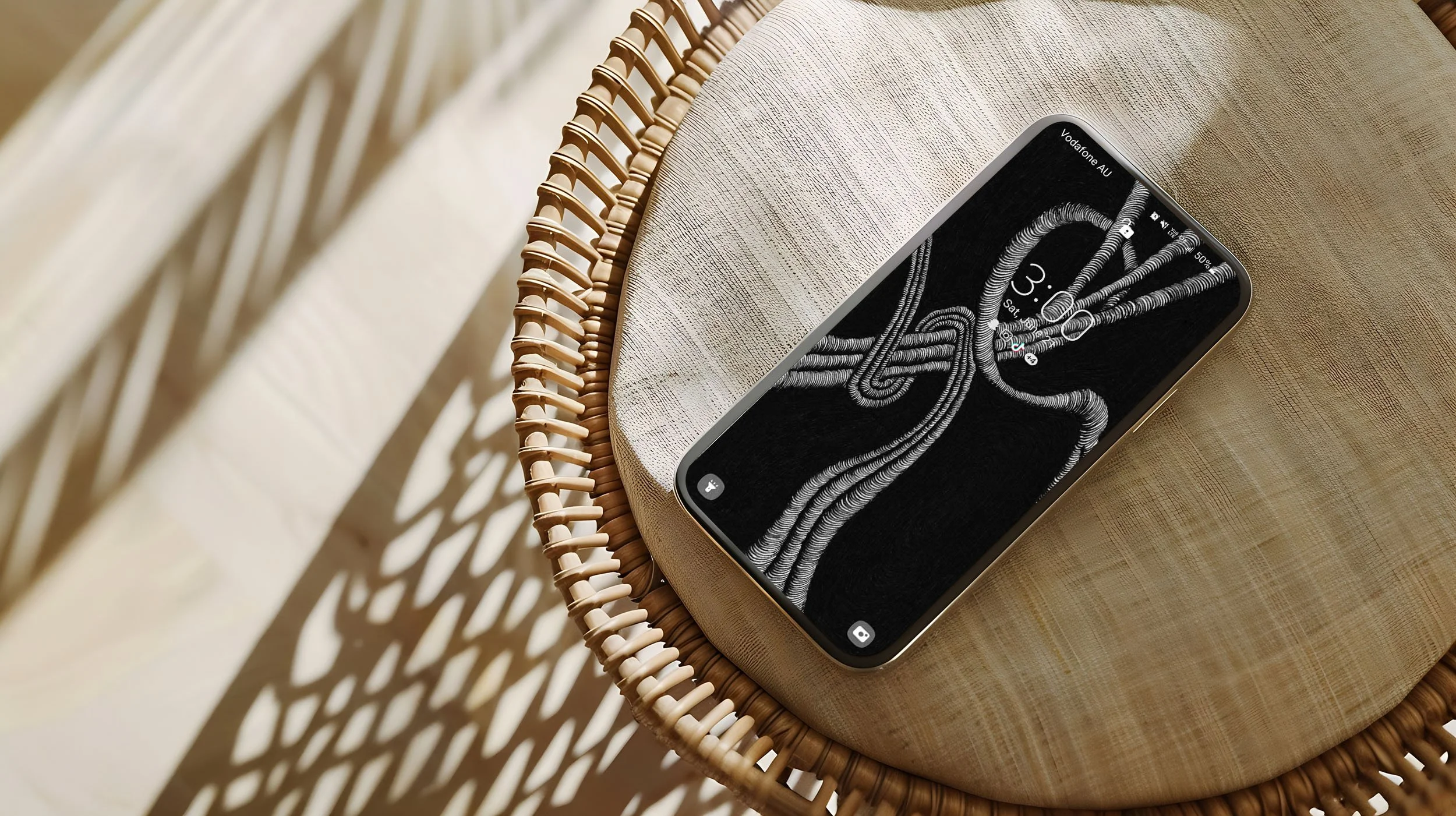 Android-phone-slaying-on-a-cushined-wicker-stool-displaying-a-lockscreen-and-unconscious-flow-line-art-and-app-icons-with-sun-and-shadow-in-the-background.jpg