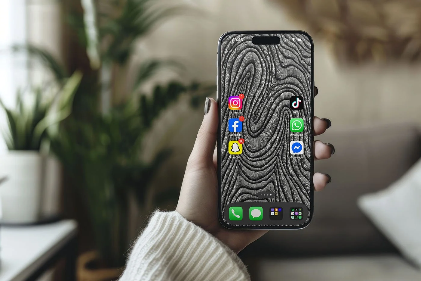 Female-holding-iphone-with-black-and-white-line-art-wallpaper-with-app-icons-with-palm-tree-and-living-room-in-the-background