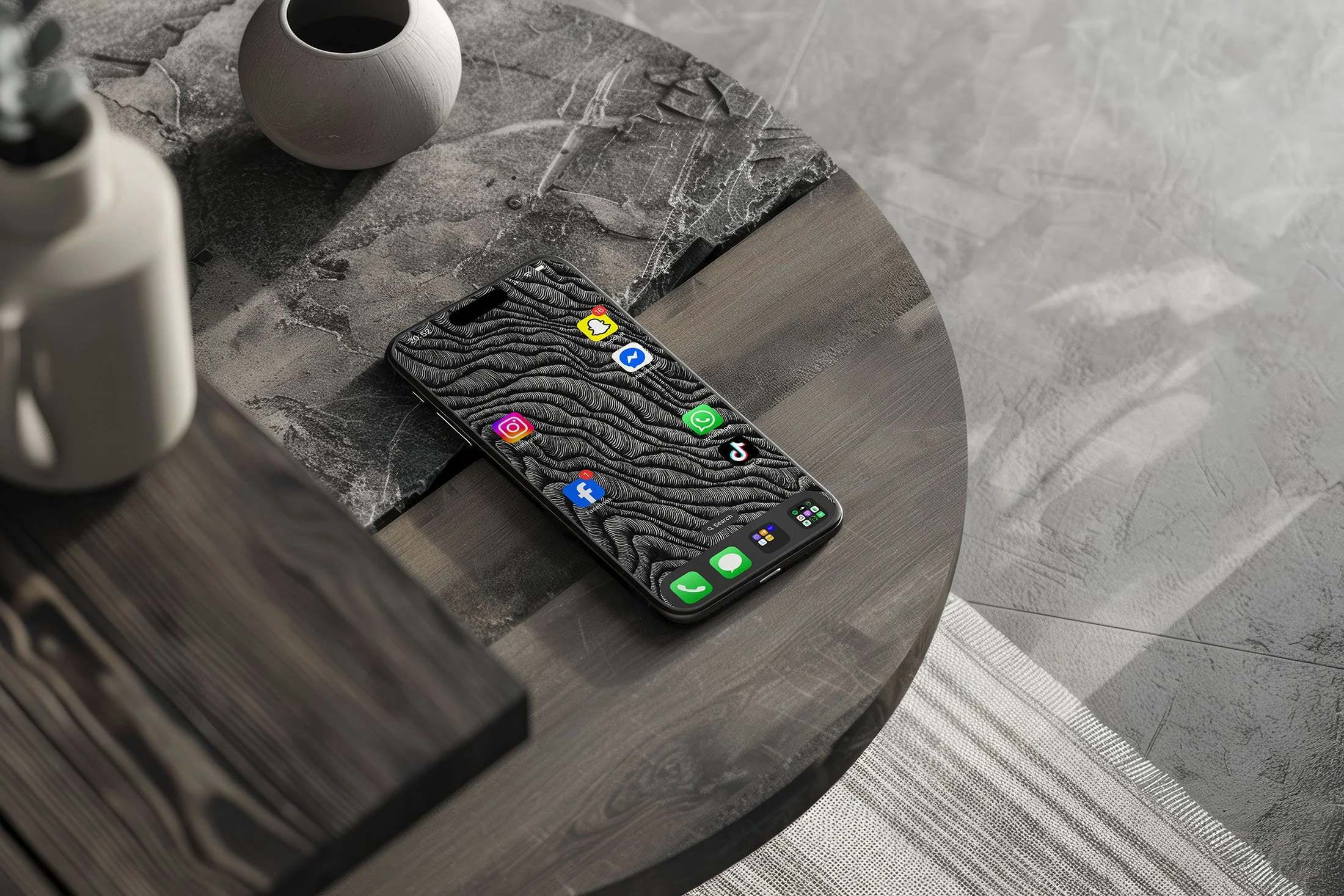 Iphone-with-black-and-white-line-art-wallpaper-with-app-icons-sitting-on-a-two-tone-stone-and-wooden-round-table