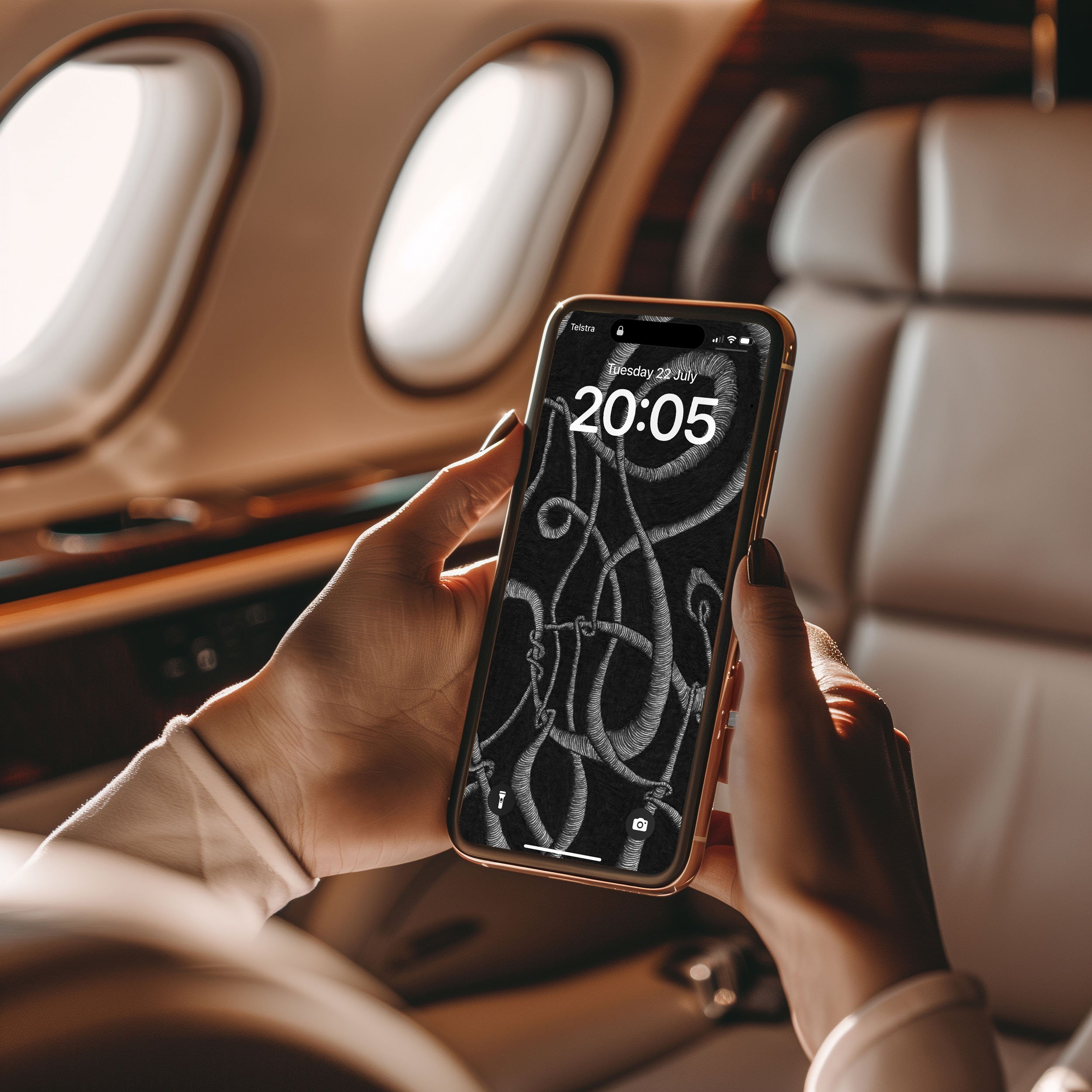 Women-sitting-in-private-airplane-holding-iphone-with-two-hands-displaying-unconscious-flow-line-art-and-lockscreen.jpg