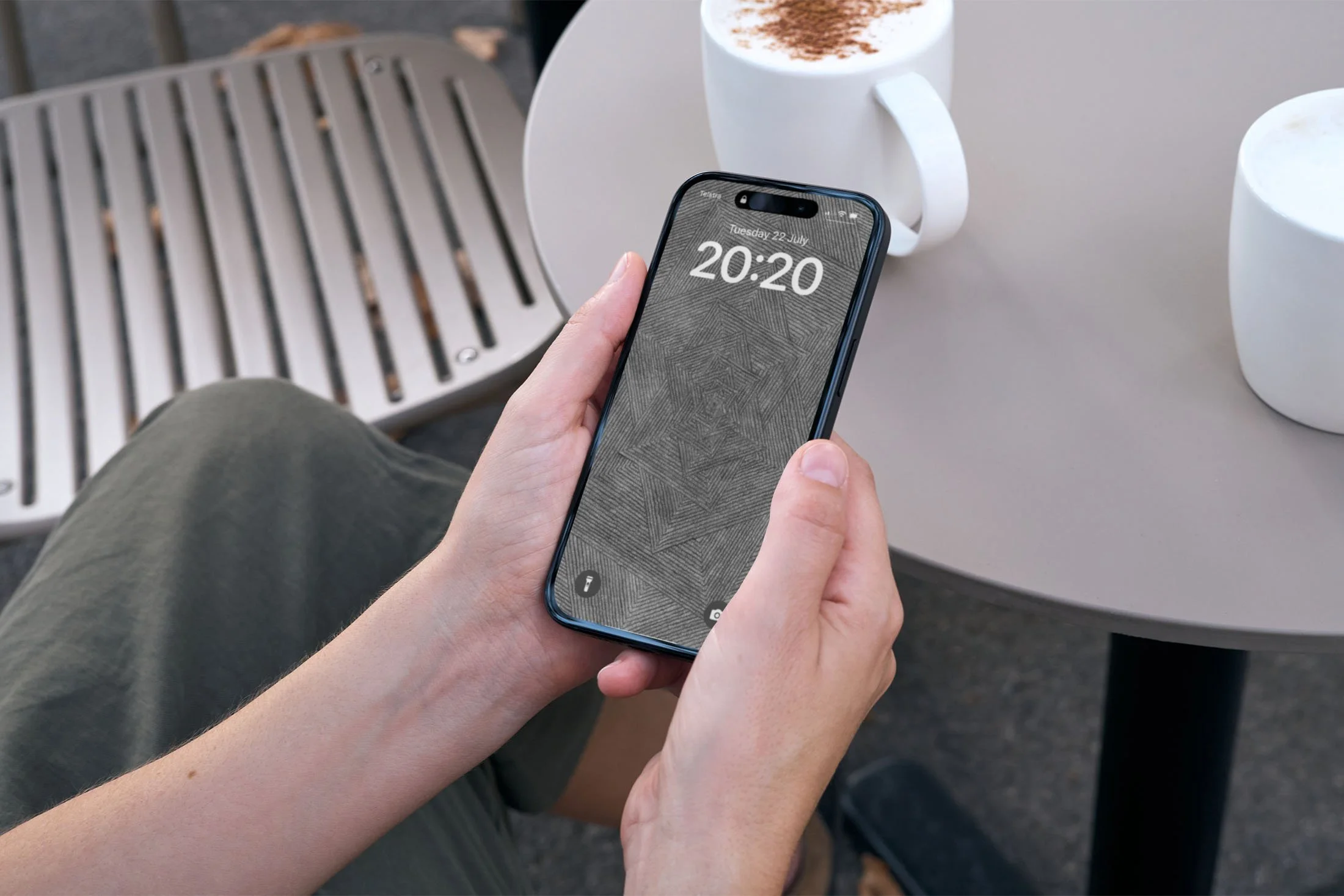 Person-sitting-alfresco-with-a-cappuccino-mug-holding-an-Iphone-with-black-and-white-line-art-wallpaper-with-lockscreen.jpg