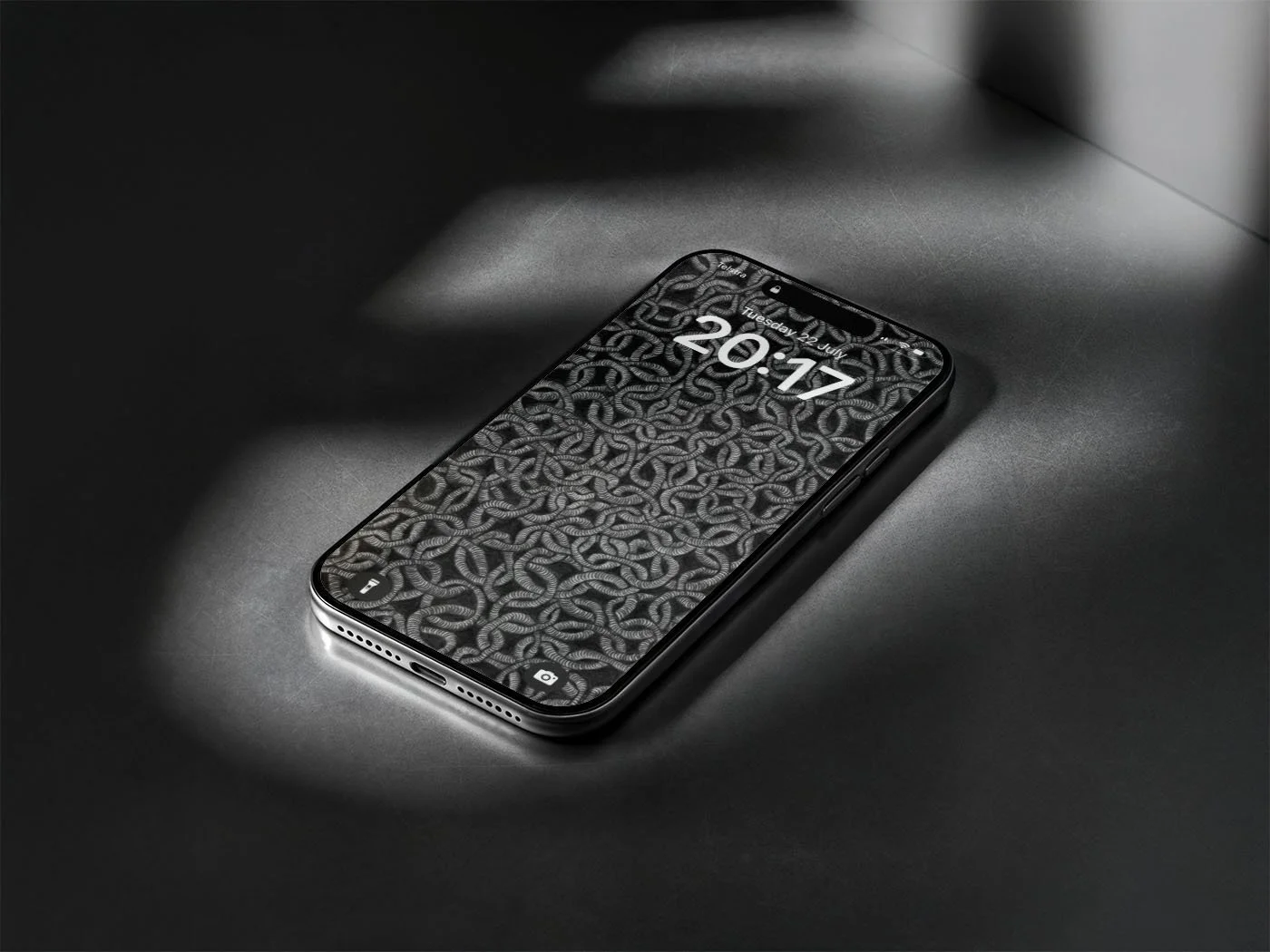 Iphone-with-black-and-white-line-art-wallpaper-laying-on-grey-surface-with dark-shadows.jpg
