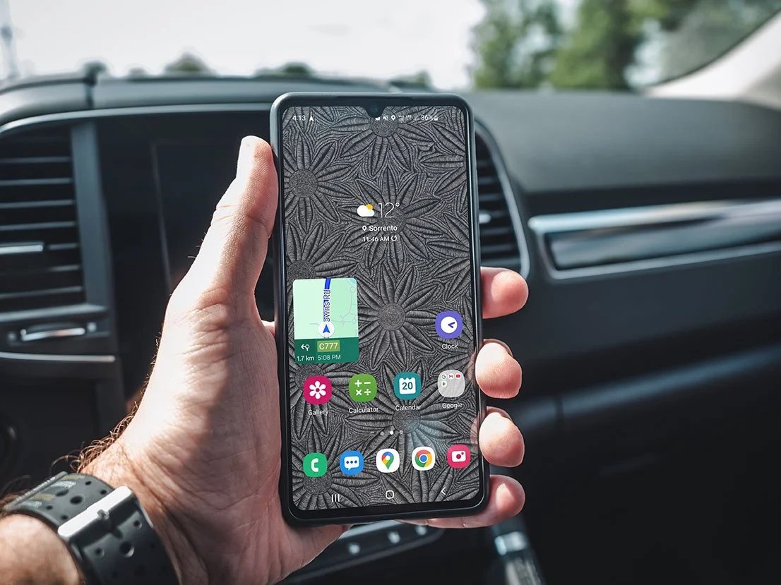 Man-holding-samsung-phone-in-car-with-black-and-white-dasie- line-art-background-with-android-apps