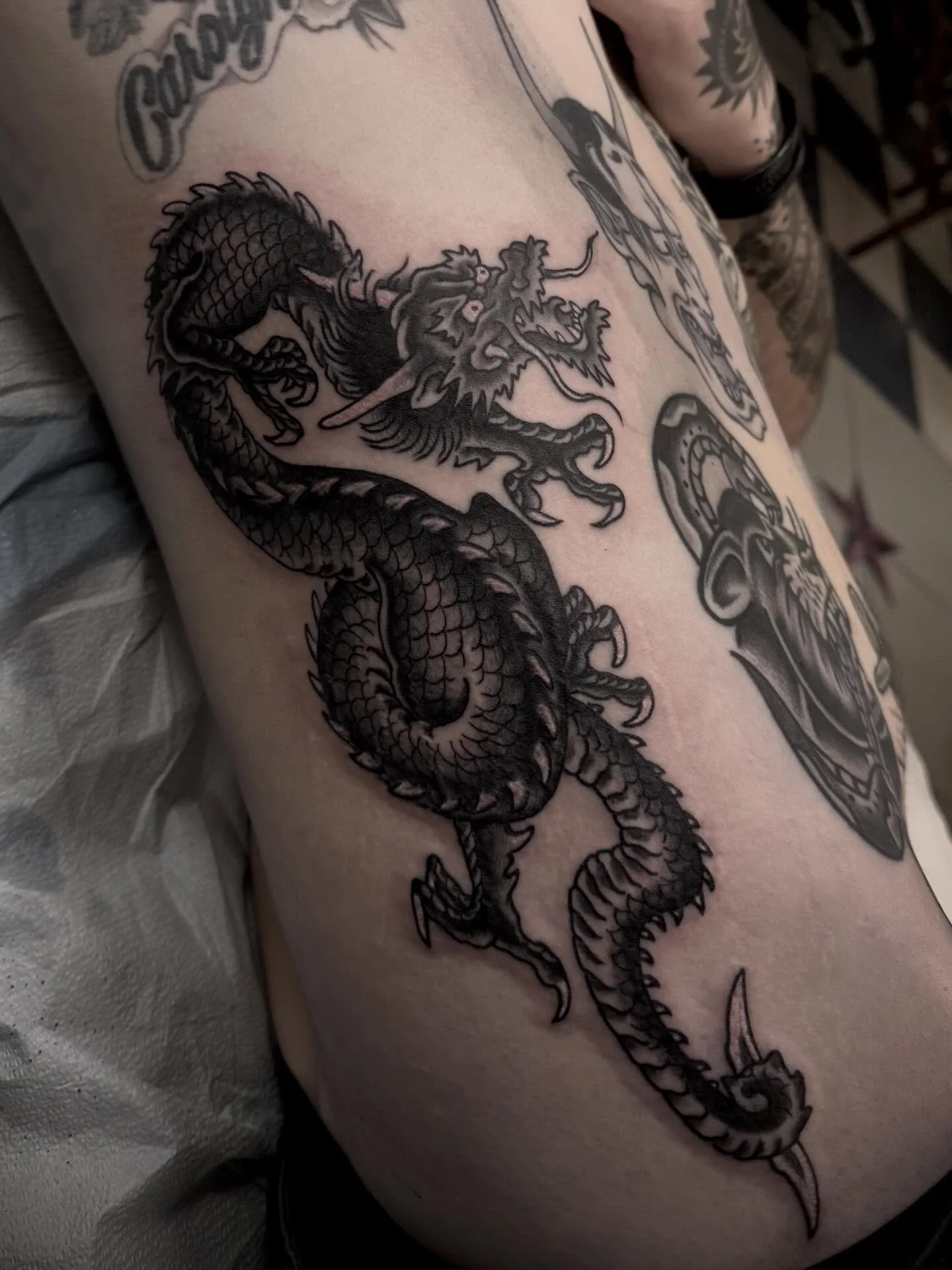 Dragon sneakin up on a bad boy tat from the mad rooter @eyeball.tattoo Visit the link in bio to book your next adventure. @elmstreettattoo