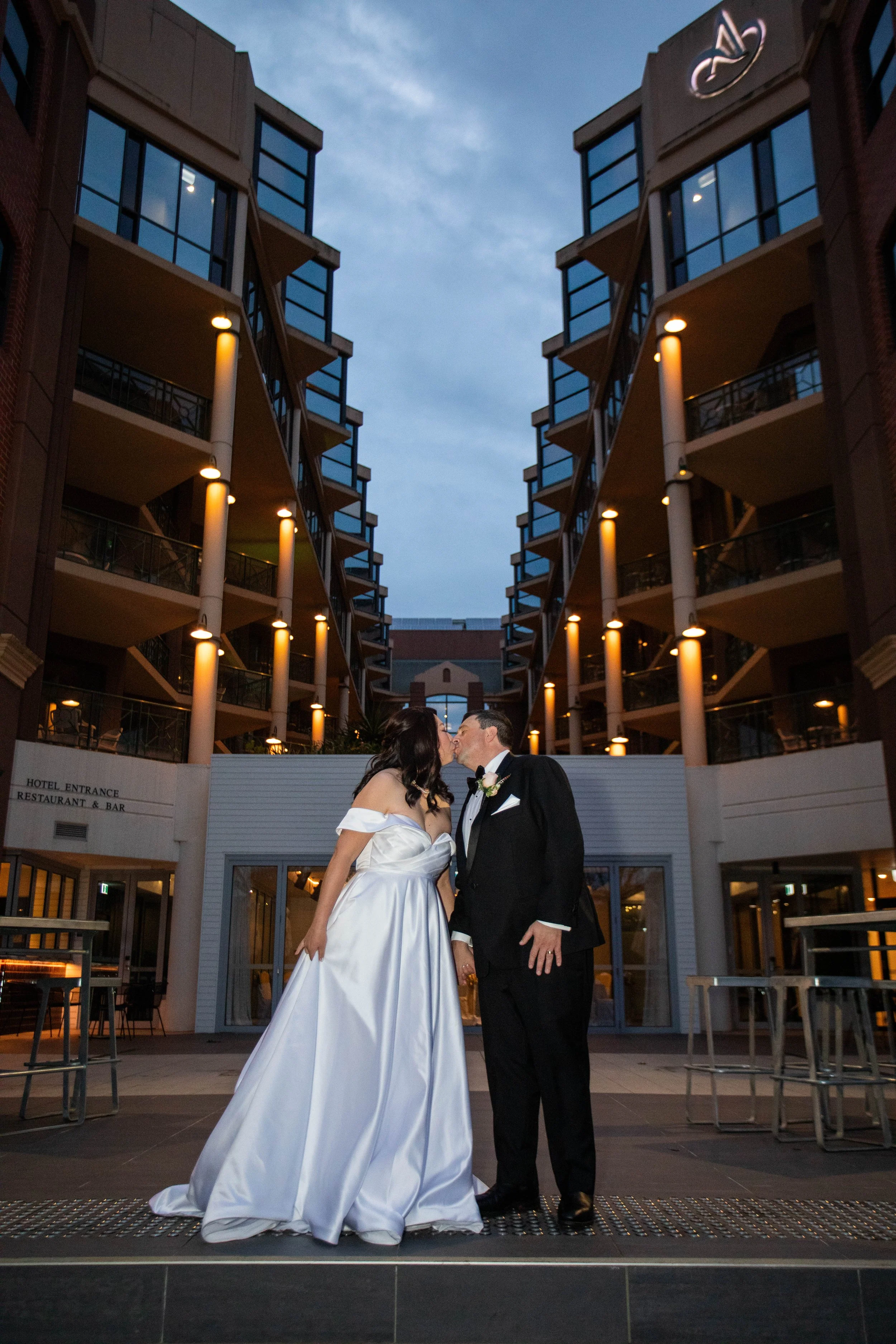 Jooah & David's kissing during their wedding photo shoot at Amora Hotel Riverwalk in Richmond