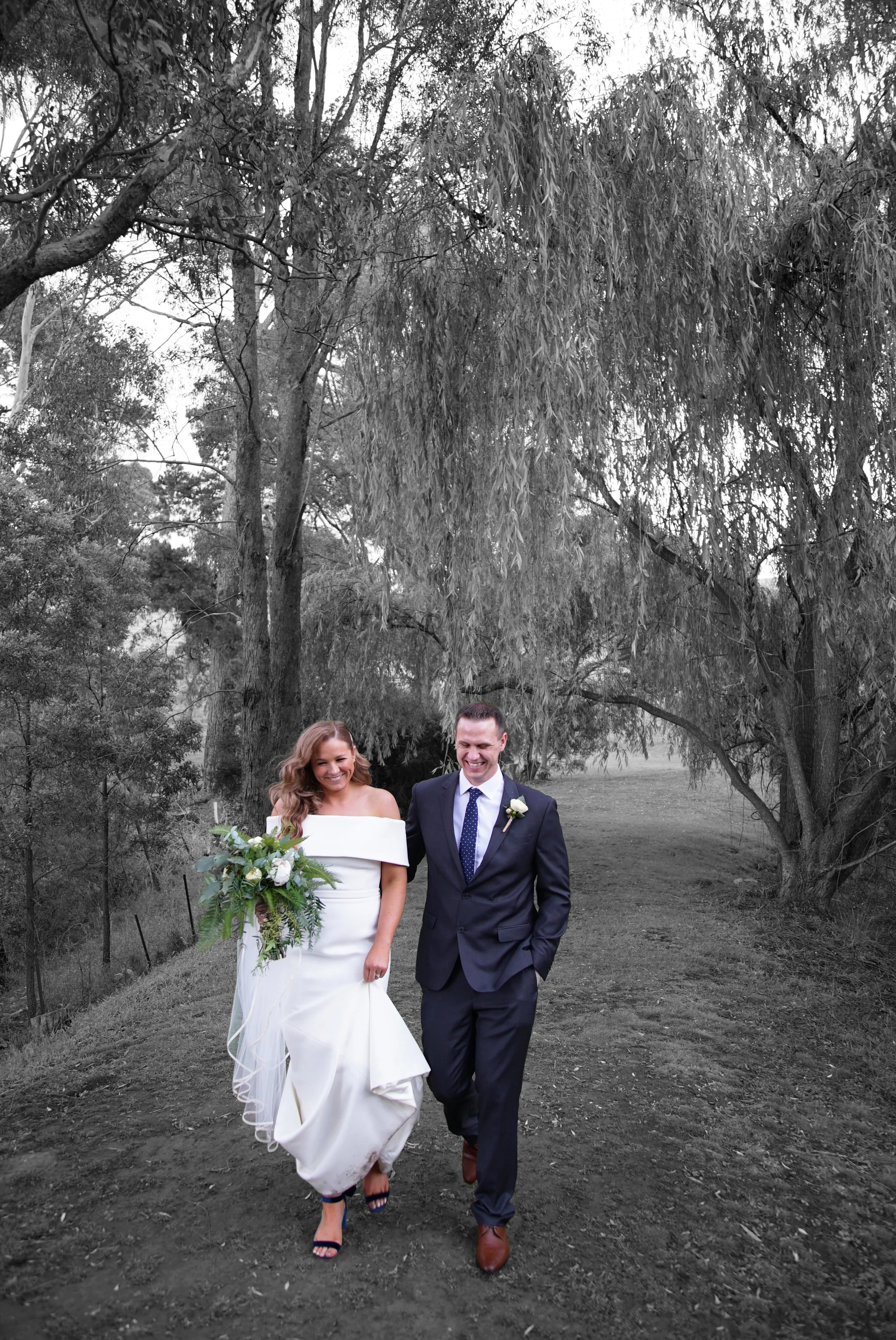 Ash and Luke's Wedding walking in their wedding dress and suit in the gardens at Inglewood Estate in Kangaroo Ground