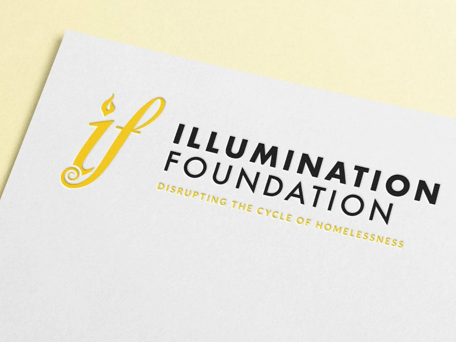 Close-up of a document titled 'Illumination Foundation' with the subtitle 'Disrupting the cycle of homelessness' on a light-colored background.