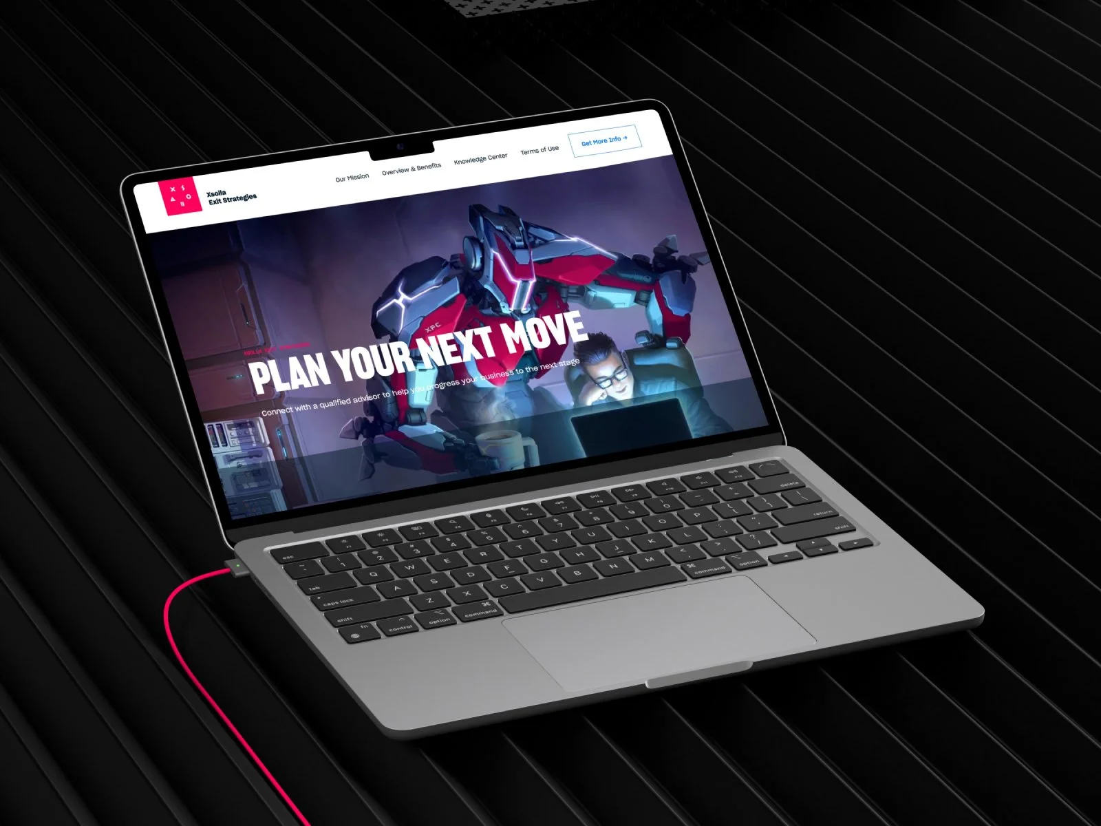 Open laptop on black textured surface displaying a website with a futuristic robot and a person working on a laptop with the text "PLAN YOUR NEXT MOVE".