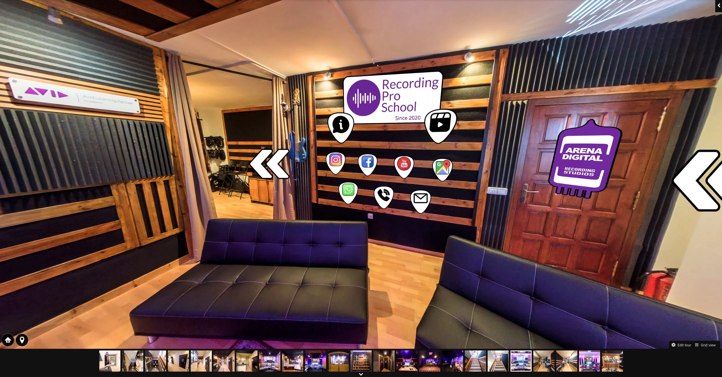 Interior del estudio de grabación de Recording Pro School con paredes de madera y paneles acústicos negros, señalización en la pared con varias redes sociales y aplicaciones, sillones negros y puerta de madera.