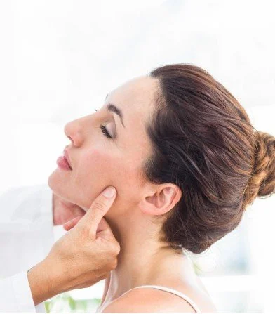 Practitioner performing TMJ disorder (TMJD) treatment on jaw and neck at The Nature of Health in Gilbert, AZ