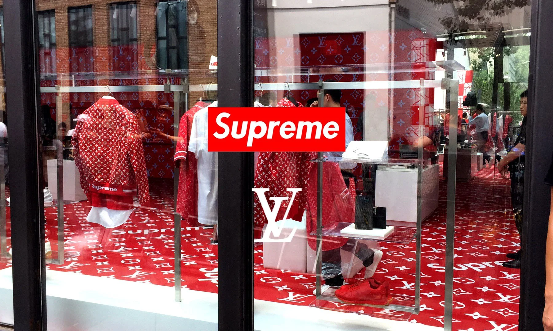 Store window of the Supreme and Louis Vuitton collaboration, showcasing red monogrammed apparel and signifying the absorption of skate subculture aesthetics by high fashion.