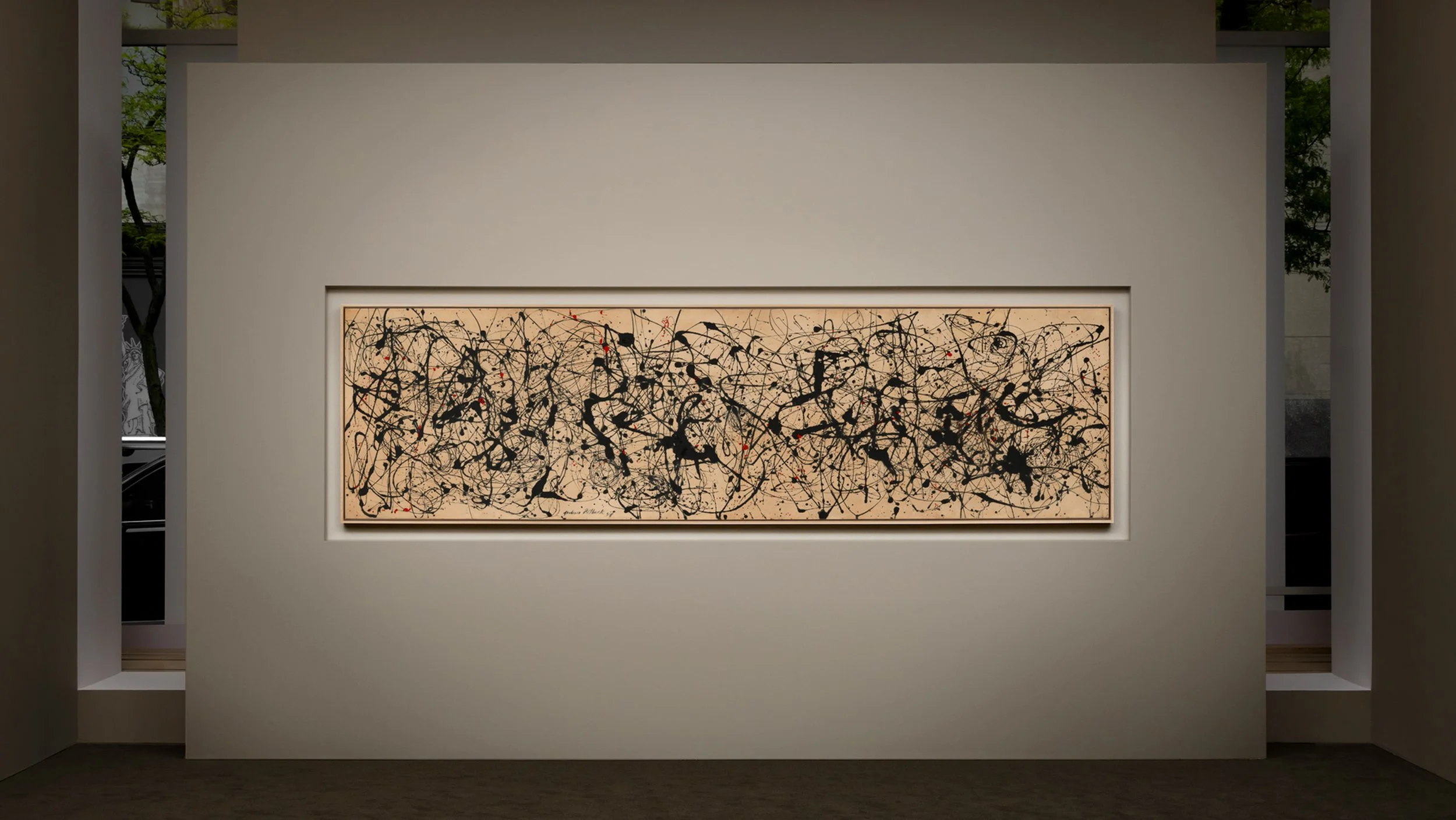 Jackson Pollock's Number 7A 1948 horizontal drip painting featuring an intricate all-over field of black, enamel, and red paint splatters, displayed flush inside a modern inset gallery wall during a museum or auction preview.