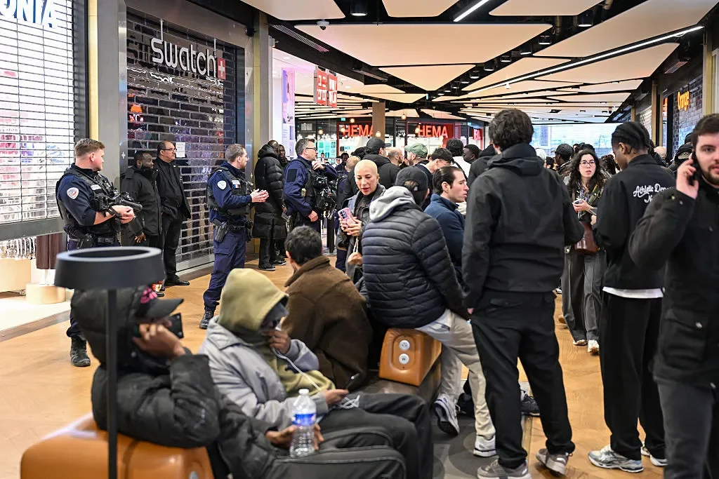 The shuttered exterior of a Swatch store at the Westfield Parly 2 shopping center in Paris, with French police officers present to manage the surging crowds gathered for the Audemars Piguet collaboration launch.