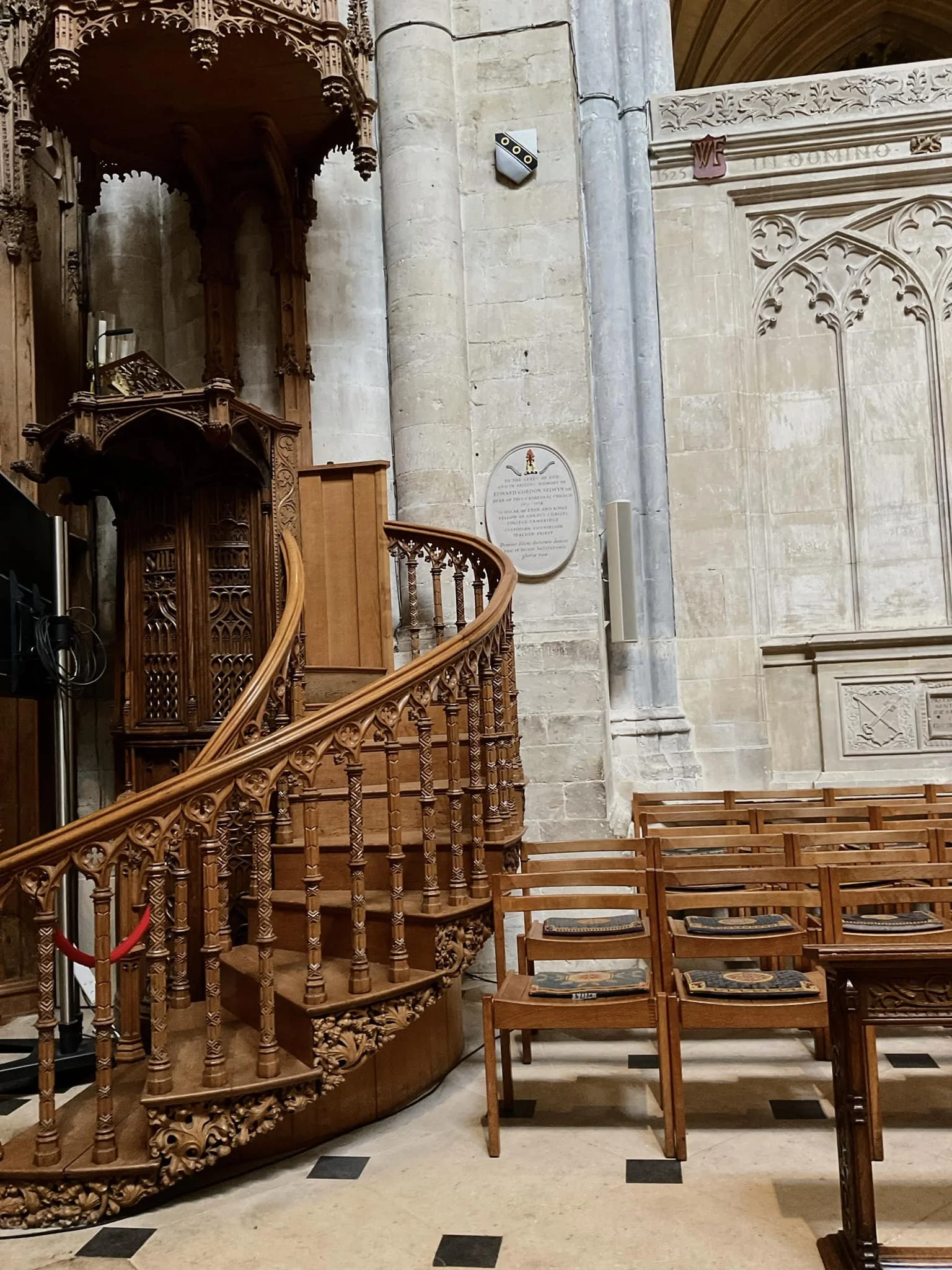 Intricately carved 14th-century solid oak ecclesiastical furniture and a spiral staircase within Exeter Cathedral, illustrating the extreme durability and aging potential of oak.