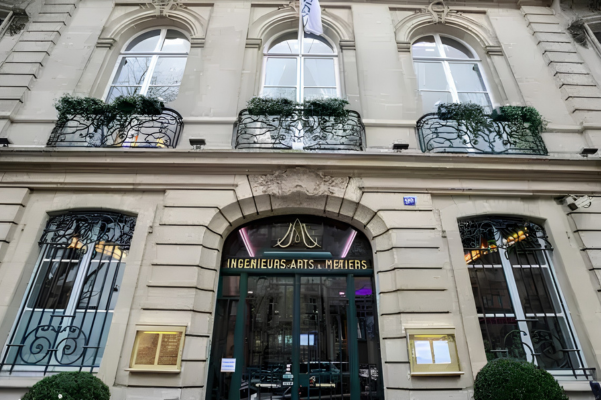 The ornate stone facade of the Salons des Arts et Métiers in Paris, featuring classical arched windows and the "Ingénieurs Arts & Métiers" signage, the site of the APA Summit where OAC concepts migrated into the luxury consulting ecosystem.