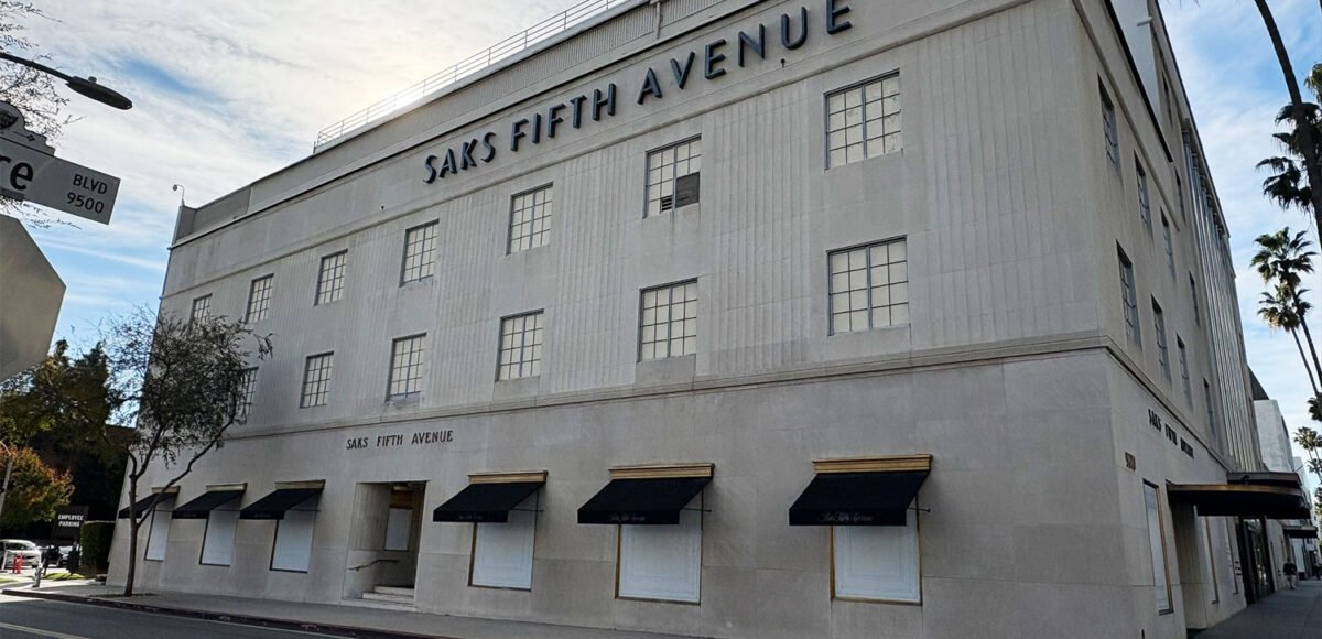 A large, multi-story Saks Fifth Avenue building with boarded-up ground-floor windows under black awnings, symbolizing the 2026 retail market contraction.