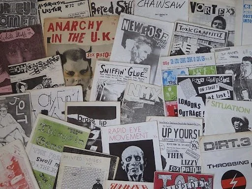 A chaotic, dense collage of vintage punk rock fanzine covers and independent publications, illustrating the diverse and unremunerated artistic dark matter.