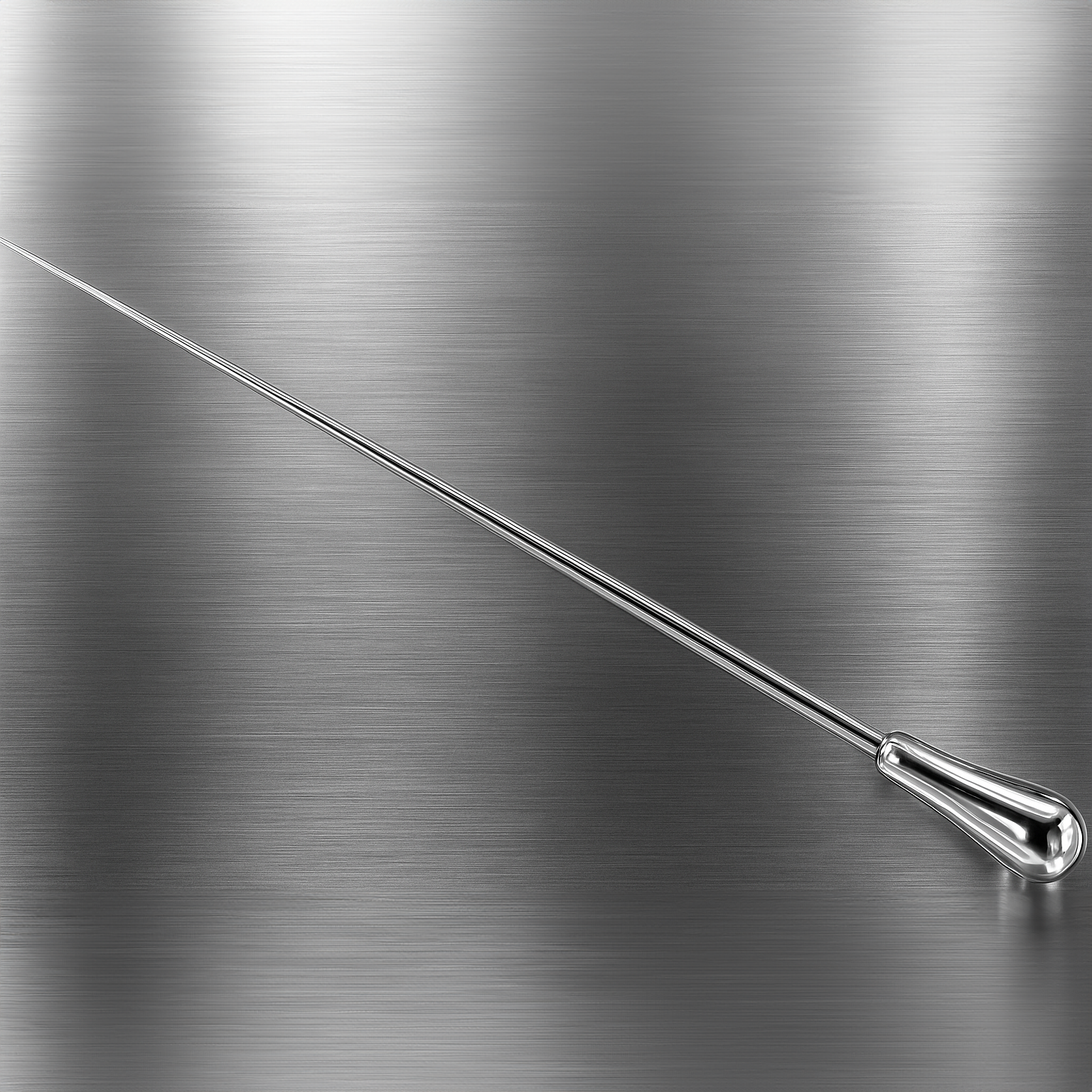 A metal conductor's baton lying diagonally on a brushed stainless steel surface.
