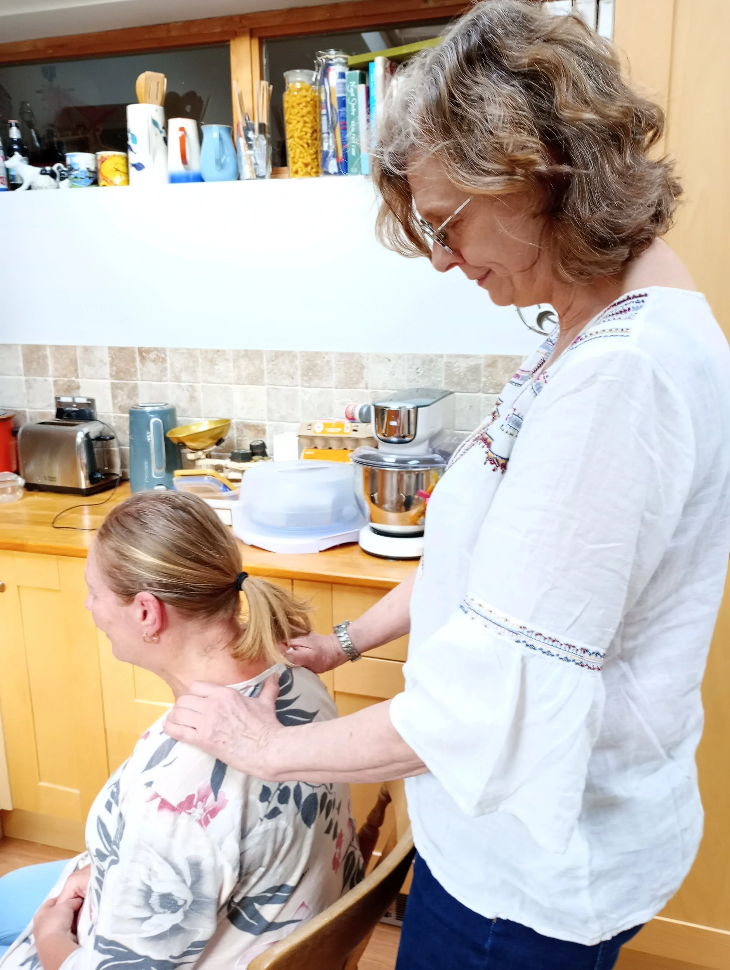 Gail giving an Indian head and shoulder massage in the kitchen