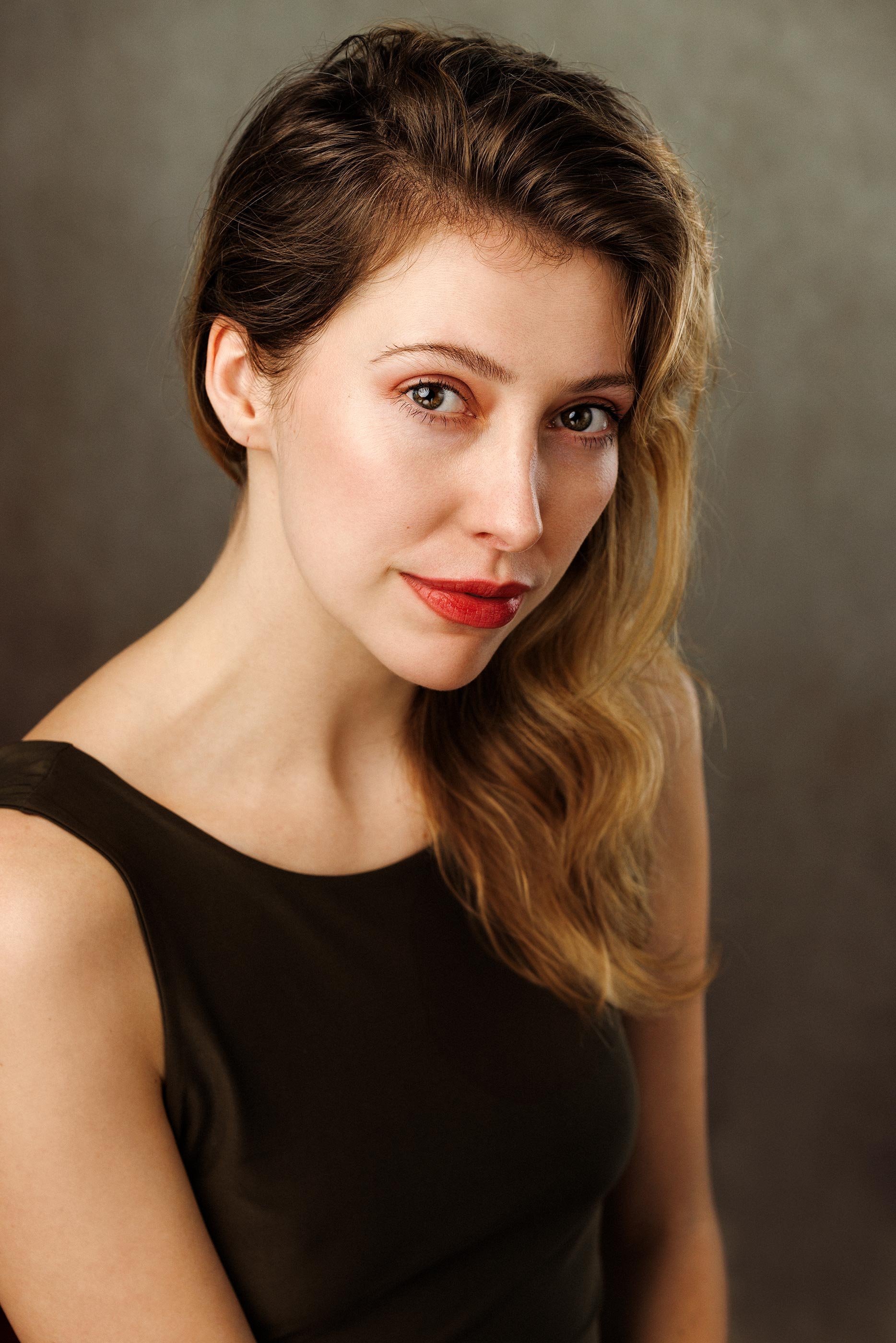 woman wearing dark brown dress looking directly into camera