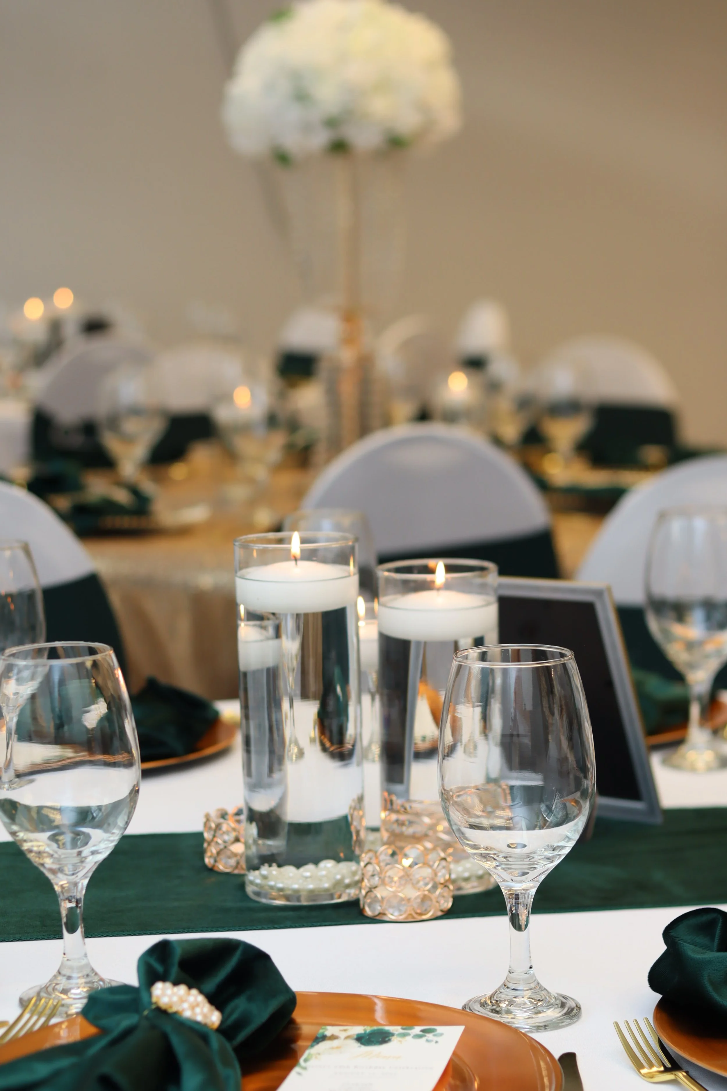 Elegant banquet table setting with candles, wine glasses, floral centerpieces, and place settings for a formal event