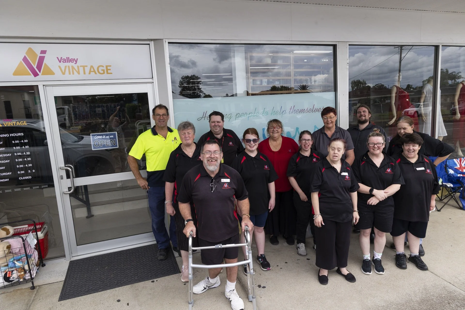Group of people standing outside Valley Vintage store, smiling for a photo.