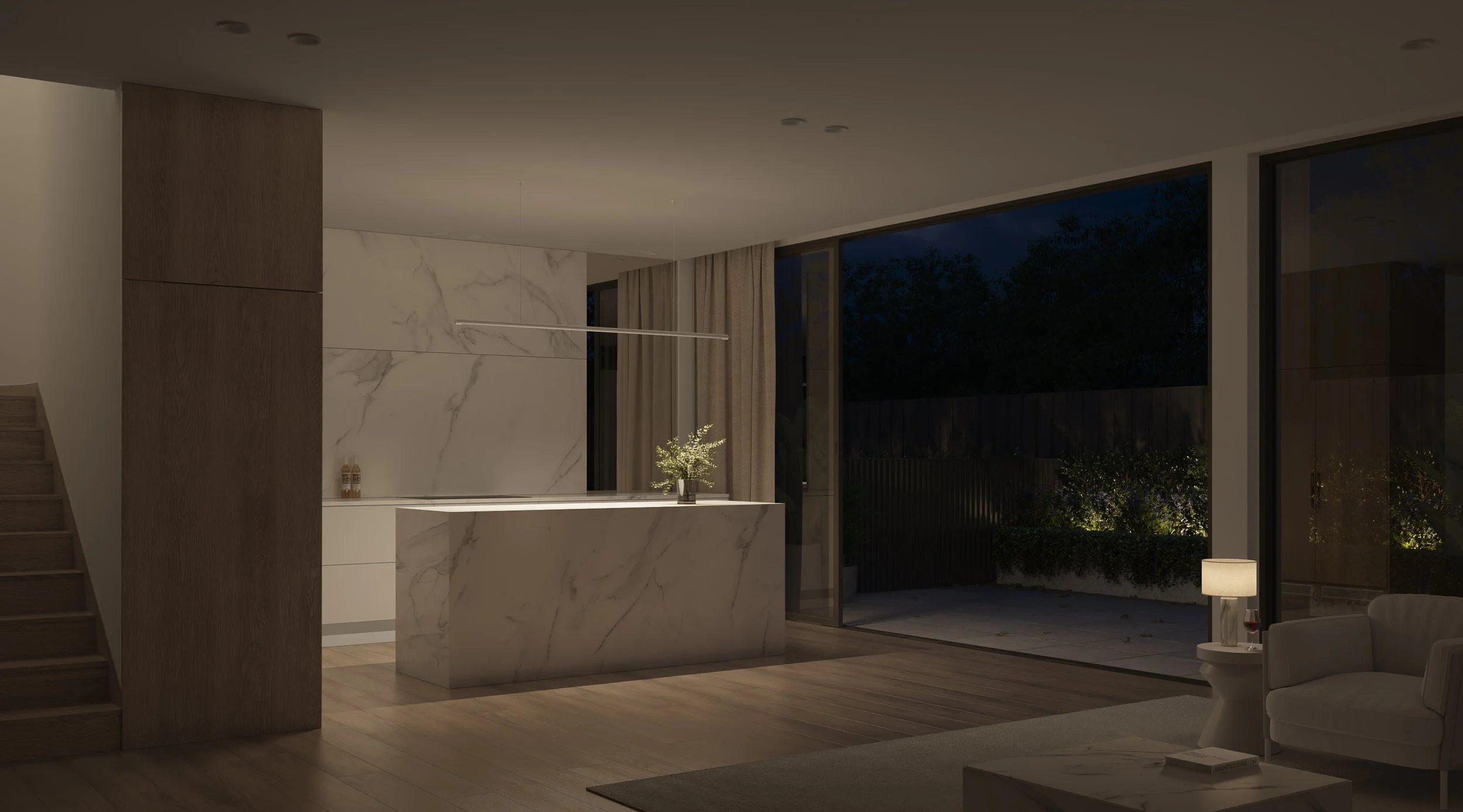 Evening kitchen interior with stone island bench and backyard view through sliding doors