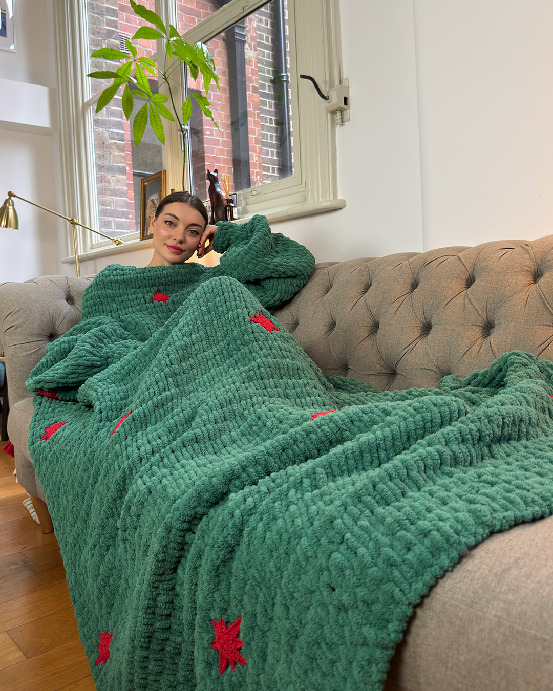 Green knitted sleeved blanket with red stars