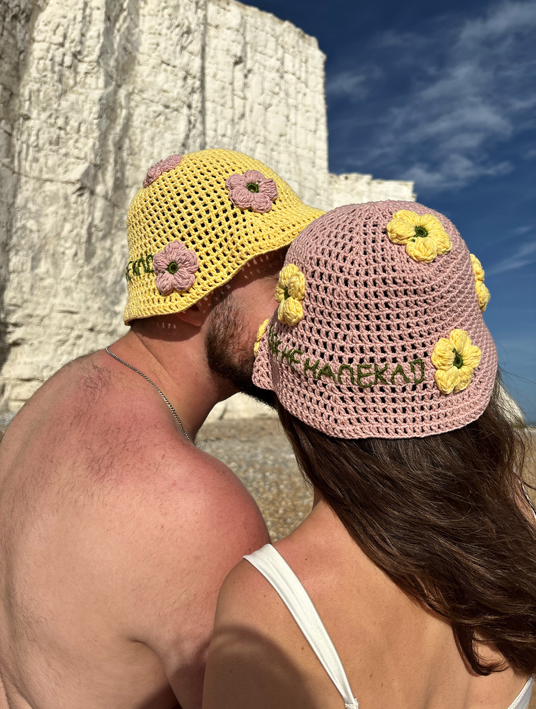 Hand-knitted hat with the text: "Щоб не напекло" in pink