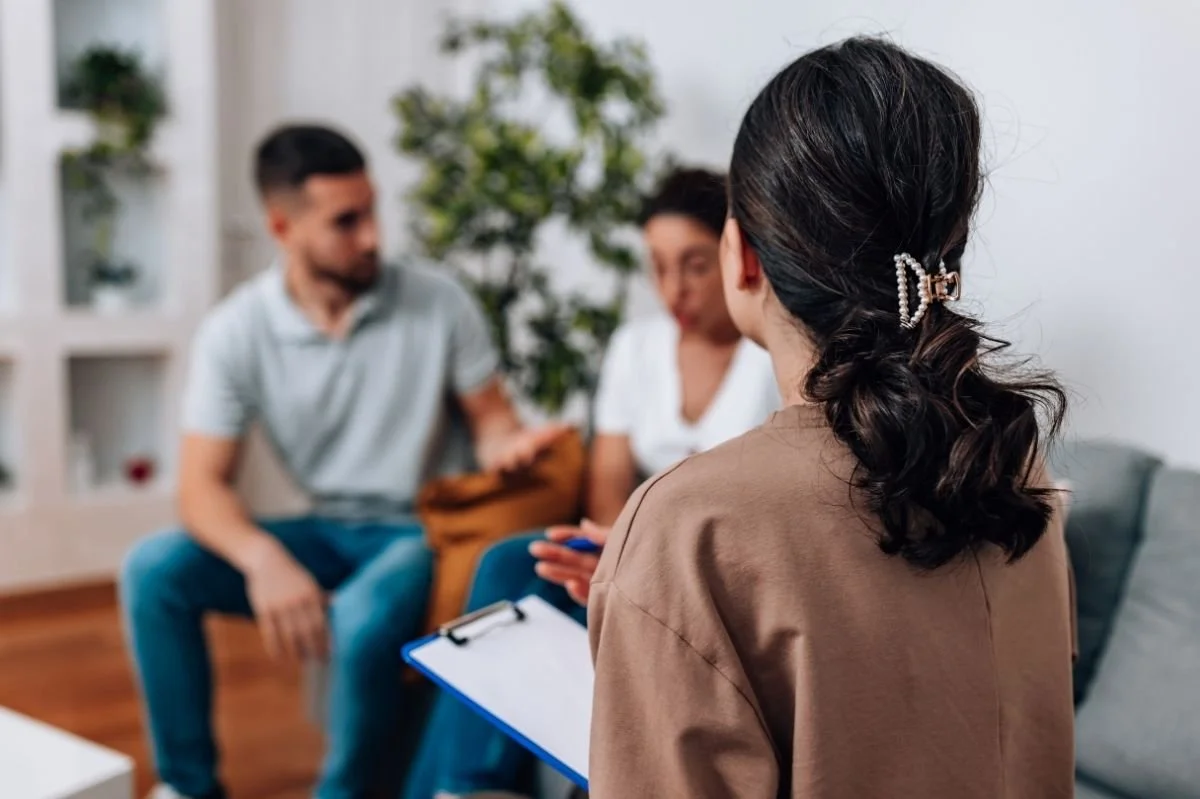Couple speaking with therapist during an in person relationship counseling session.
