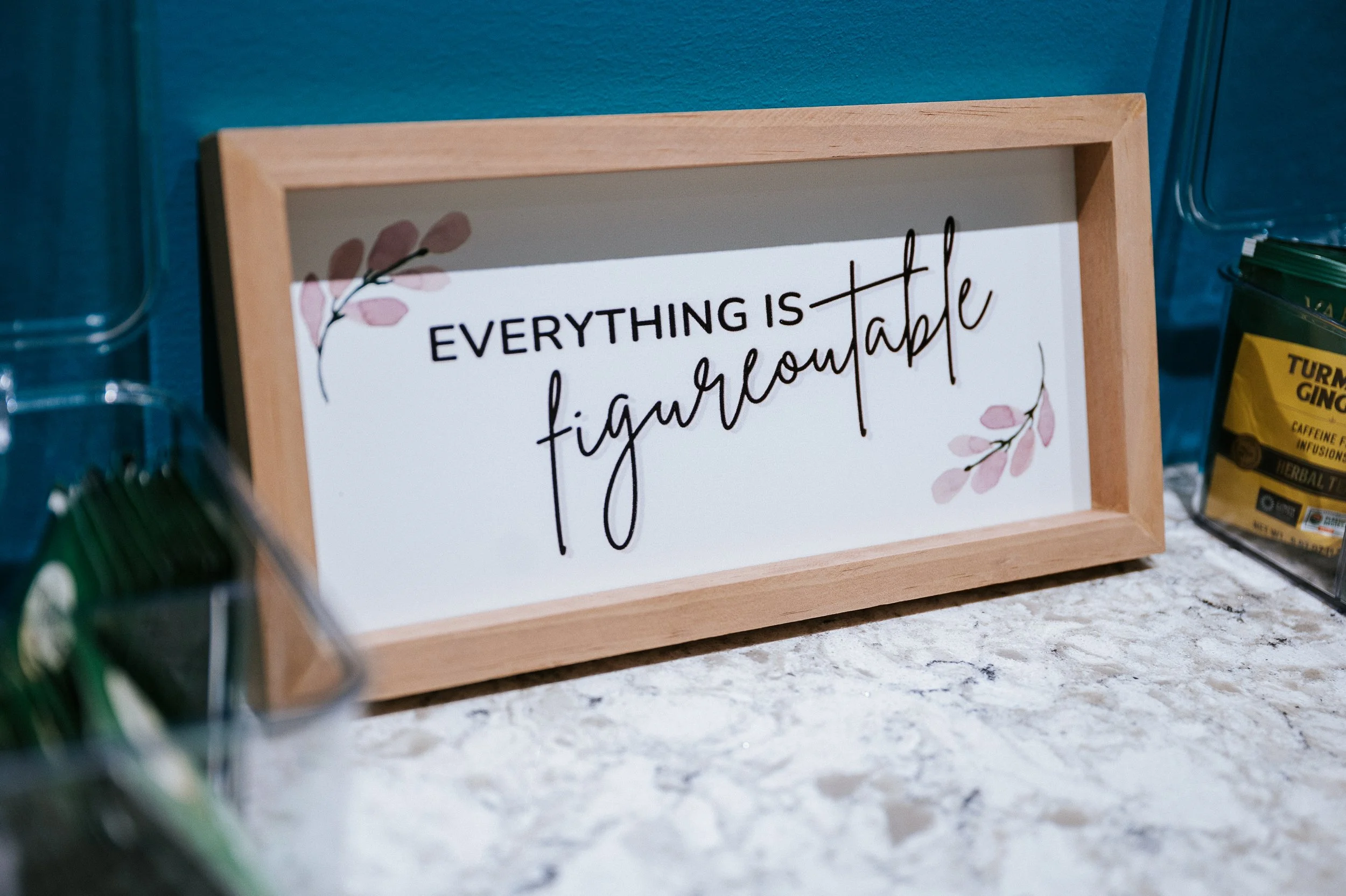 Framed sign in counseling office that reads Everything is figureoutable displayed on reception counter.