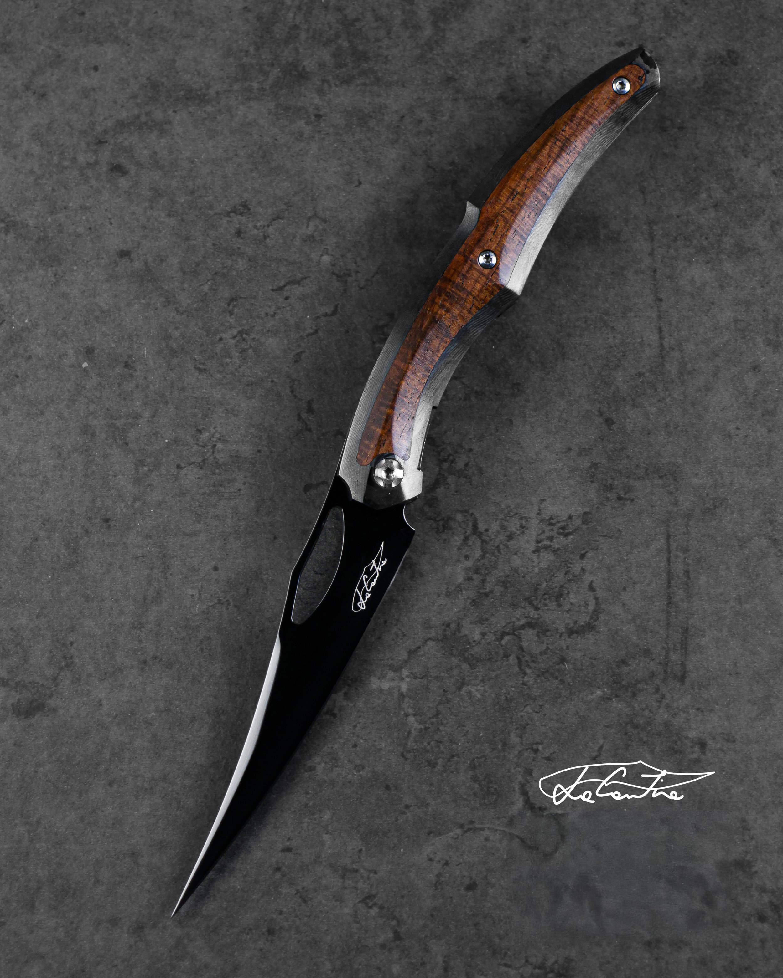 BLADE: polished RWL34 with DLC treatment.
HANDLE: Carbon frame, rosewood insert, Tempered steel with DLC mechanich and clip