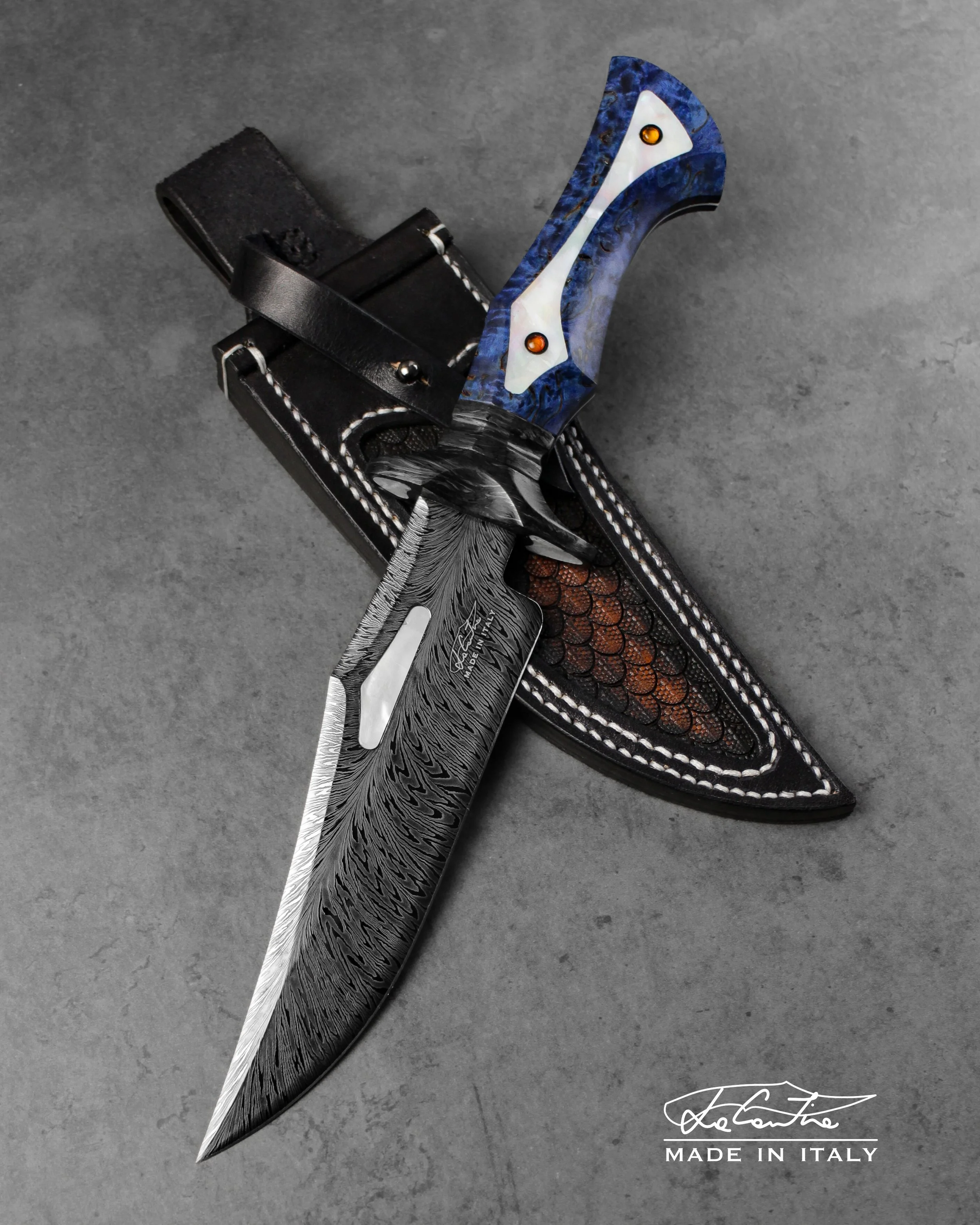 LAMA: Damasco piuma con trattamento DLC.
IMPUGNATURA: Guardia e distanziale in carbonio, betulla blu stabilizzata, inserti in madreperla, pin in carbonio con gemme d'ambra.
FODERO: Cuoio lavorato e cucito a mano.