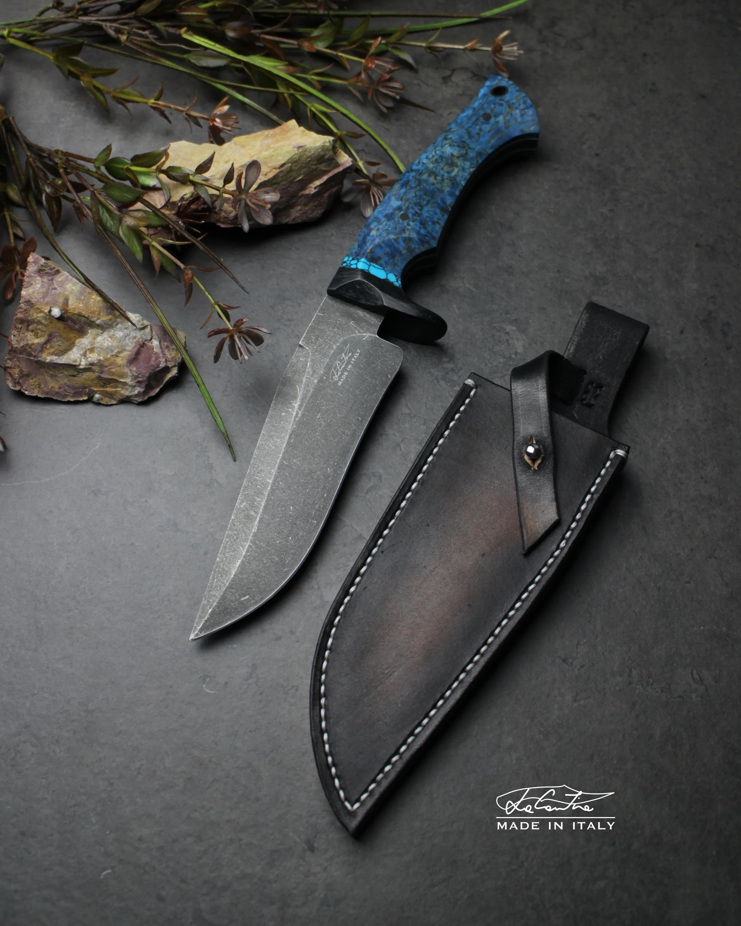 LAMA: Sleipner, 59-60HRC. 
MANICO: Legno di betulla stabilizzata blu, spaziatore pietra turchese ricostruita, guardia e pin in carbonio, g10 bianco.