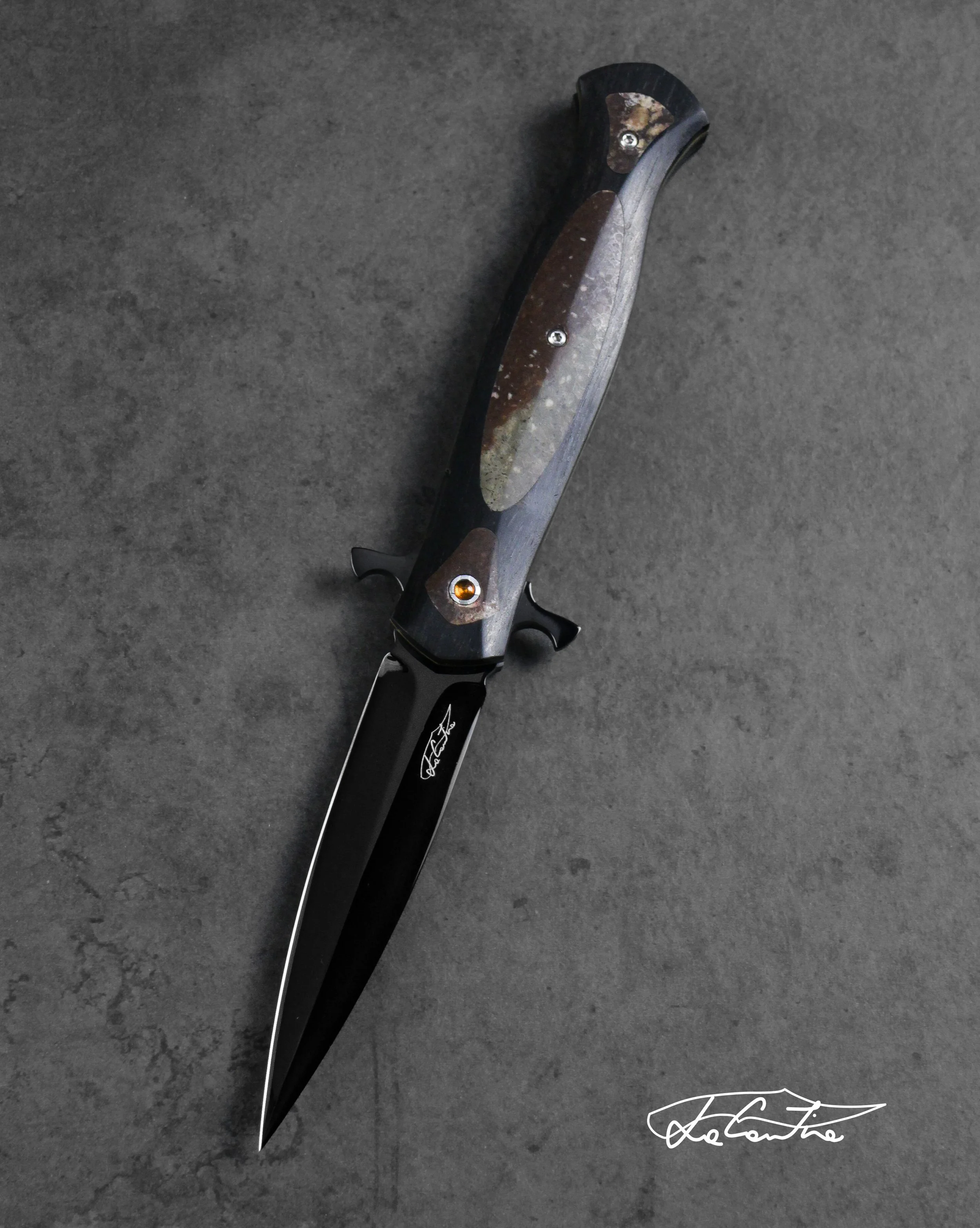 LAMA: RWL34 lucidato con trattamento DLC. MANICO: frame in ebano, inserti in osso fossile di dinosauro, gemme di ambra incastonate nel perno, G10 giallo, meccanica in acciaio temperato con DLC, distanziale in carbonio