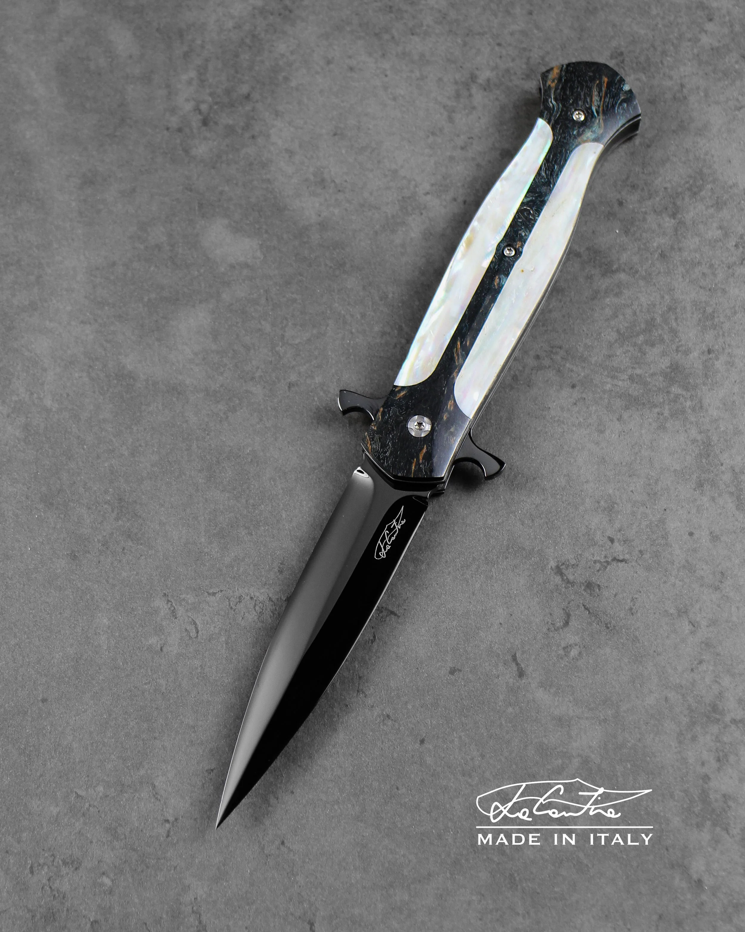 LAMA: RWL34 lucidata con trattamento DLC. MANICO: frame in betulla stabilizzata (verde scuro), inserti in madreperla, G10 bianco, meccanica in acciaio temperato con DLC, distanziale in carbonio.
